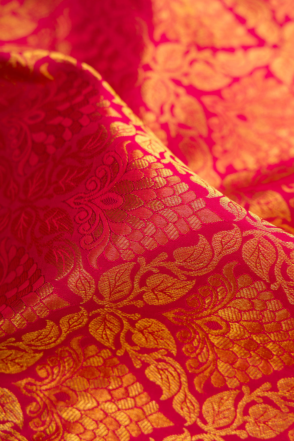 Close up of Maroon Dual Tone Kanjivaram Silk Saree with Zari Brocade on the body and Zari Border.  displaying folds