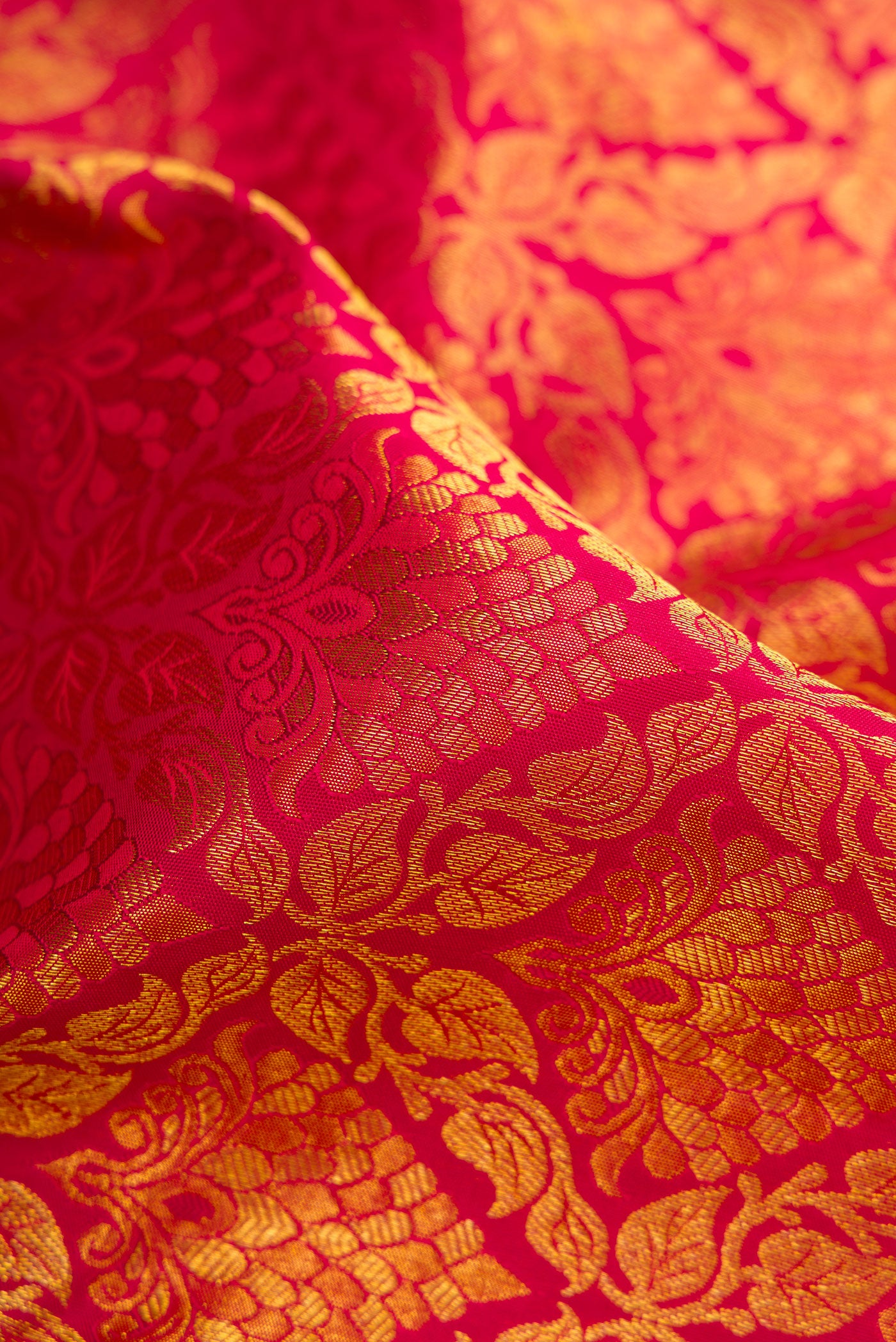 Close up of Maroon Dual Tone Kanjivaram Silk Saree with Zari Brocade on the body and Zari Border.  displaying folds