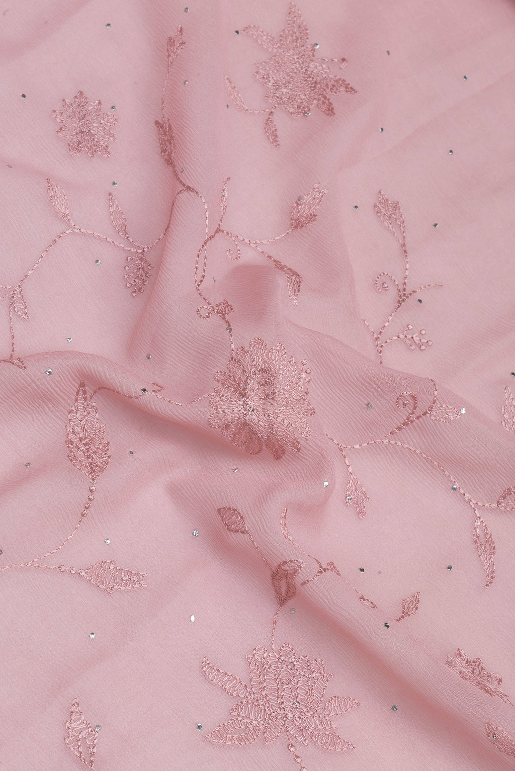 Close up of Rose Gold Chiffon Saree with Embroidery on the body and Embroidery Border.  displaying folds