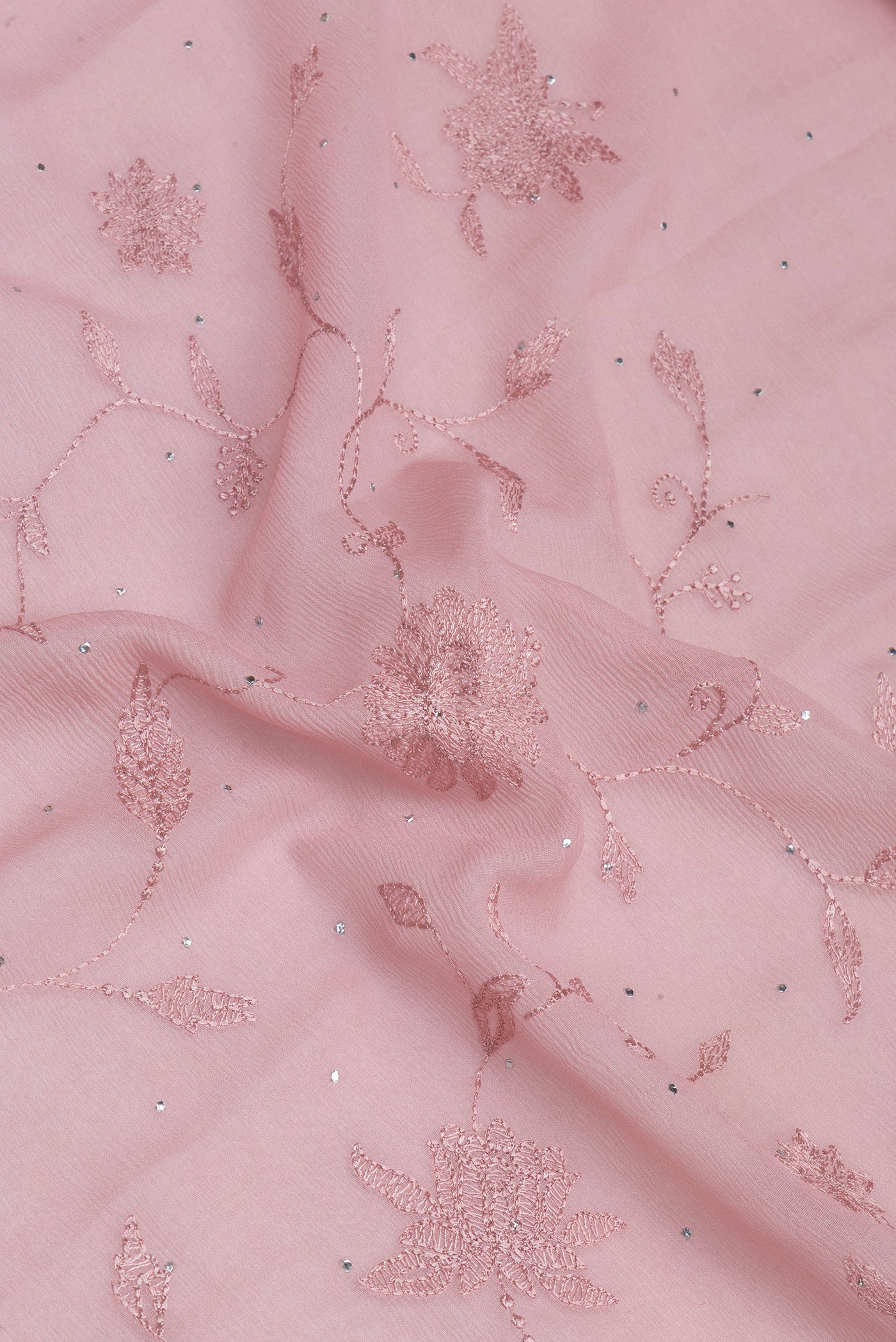 Close up of Rose Gold Chiffon Saree with Embroidery on the body and Embroidery Border.  displaying folds