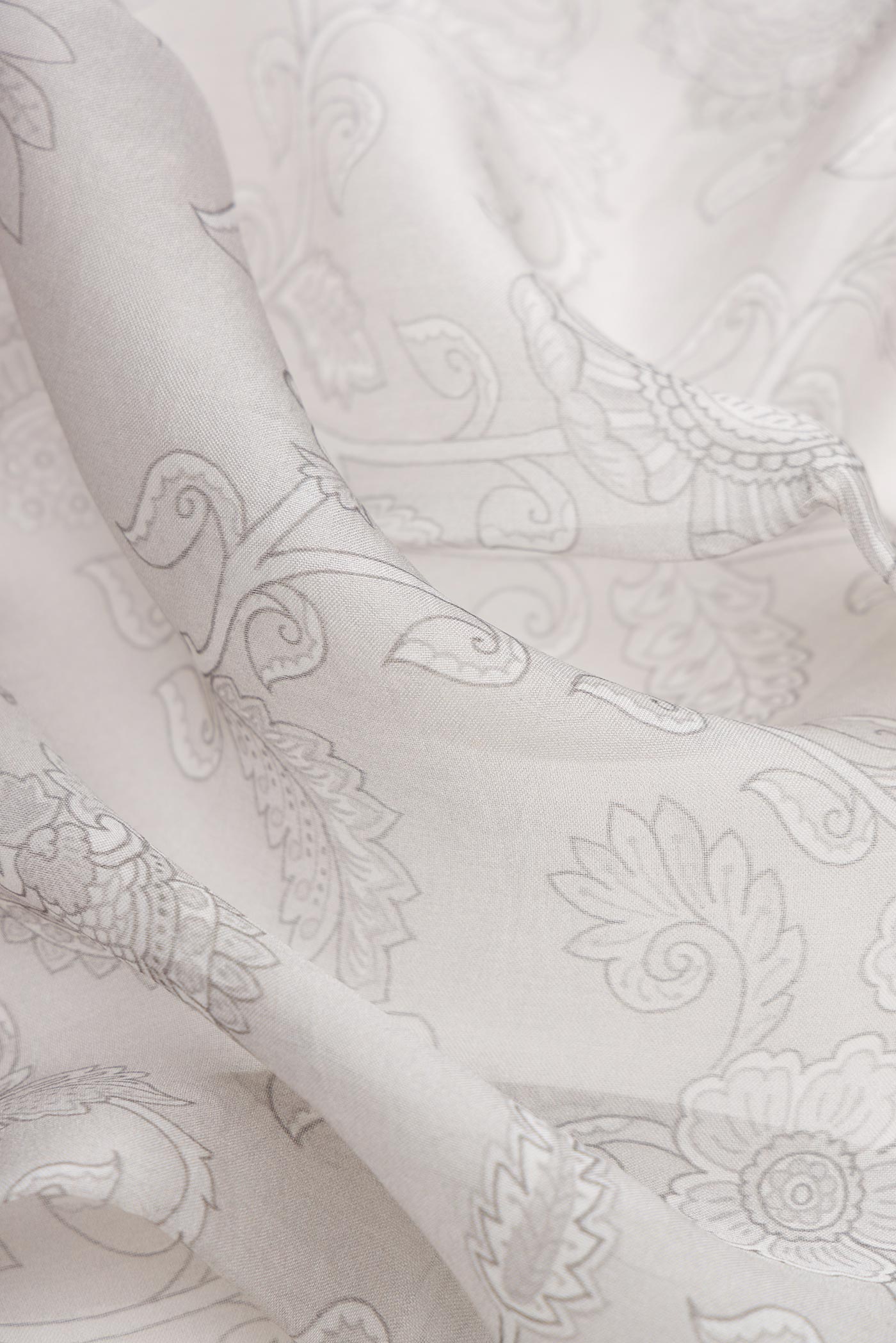 Close up of Grey Dual Tone Organza Silk Saree with Printed design on the body and Embroidery Border.  displaying folds