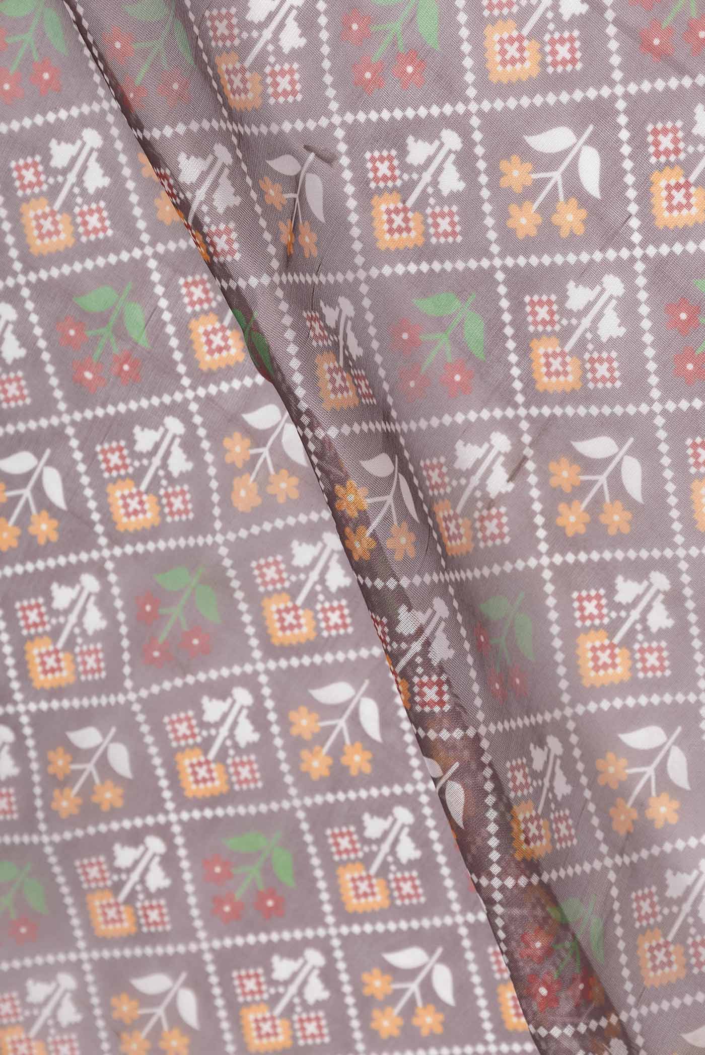 Close up of Brown Dual Tone Organza Silk Saree with Printed design on the body and Embroidery Border displaying folds