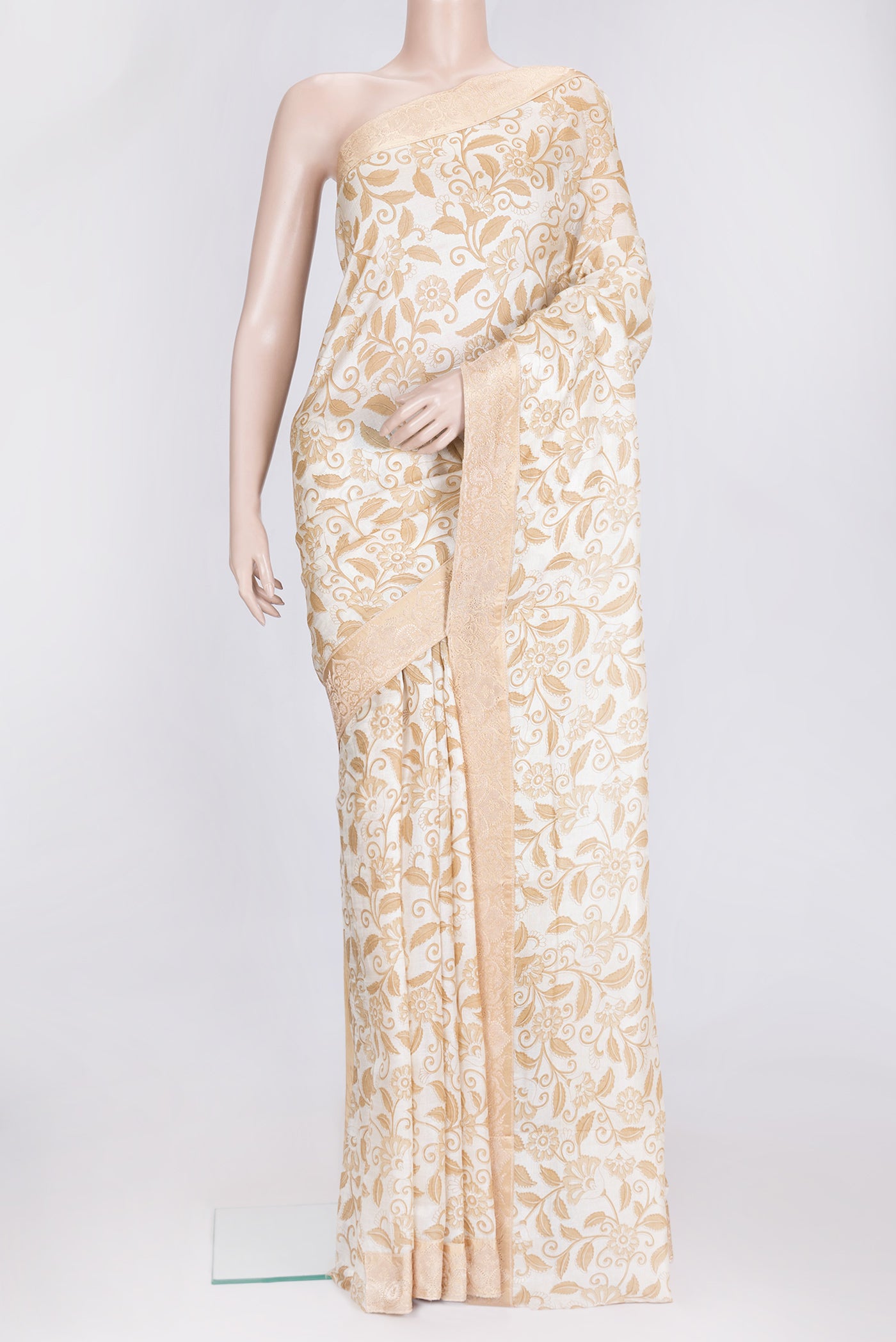 Off White Dual Tone Tussar Silk Saree with Printed design on the body and Zari Border.  displayed on a mannequin