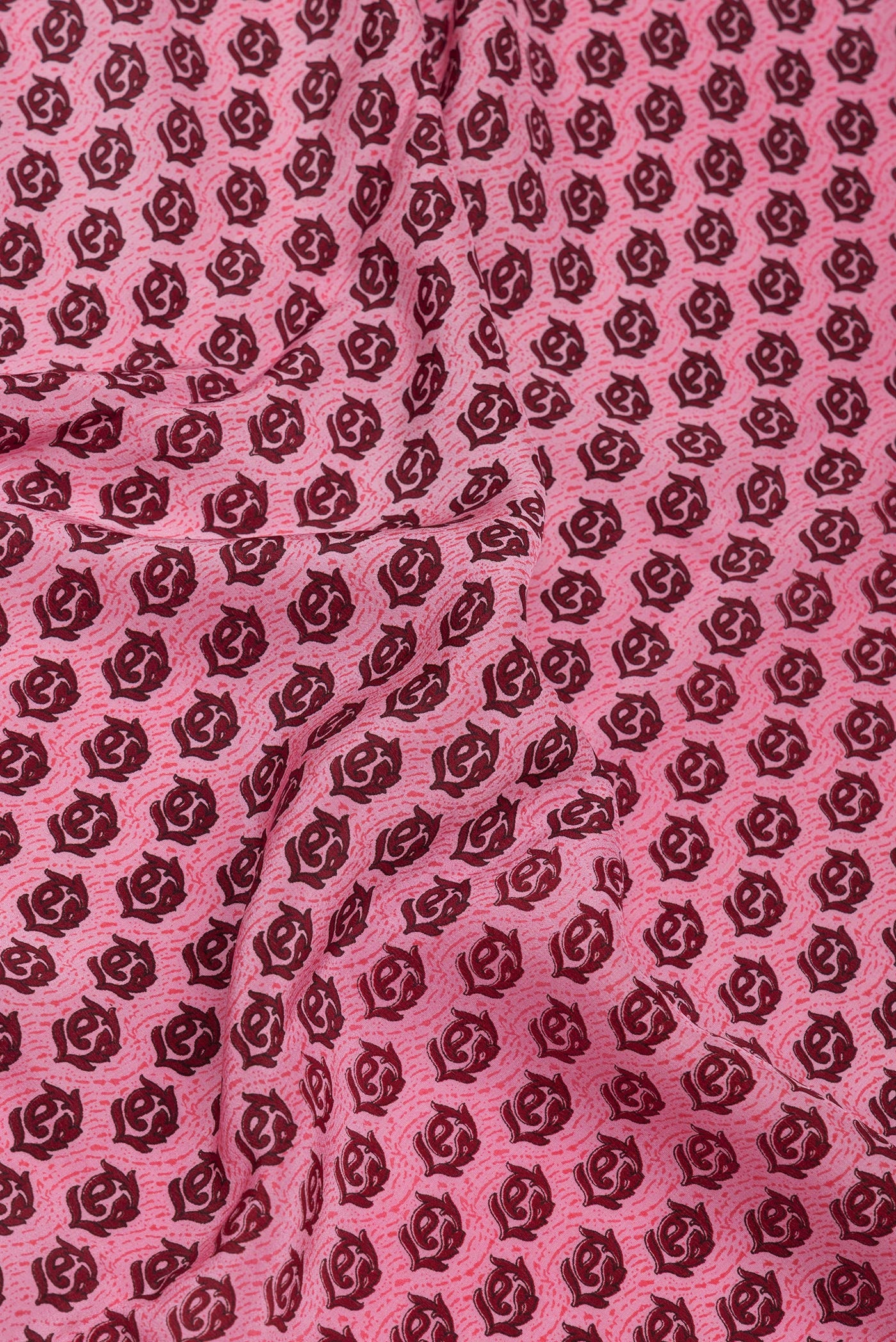 Close up of Pink Crepe Saree with Printed design on the body and Printed Border.  displaying folds
