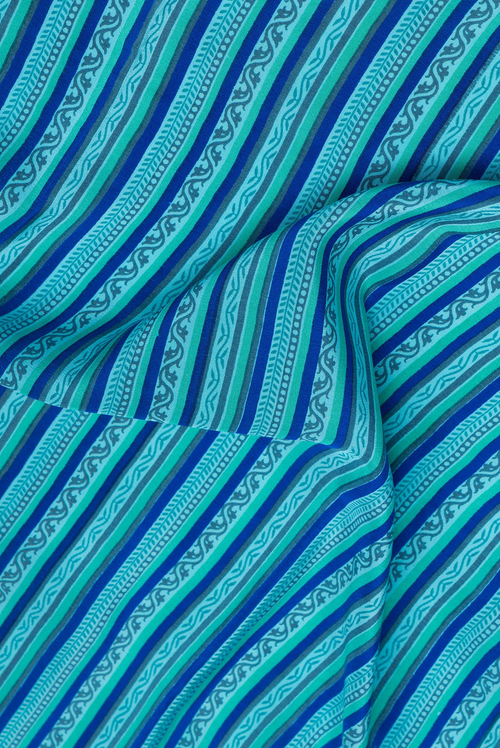 Close up of Blue Crepe Saree with Printed design on the body and Printed Border.  displaying folds