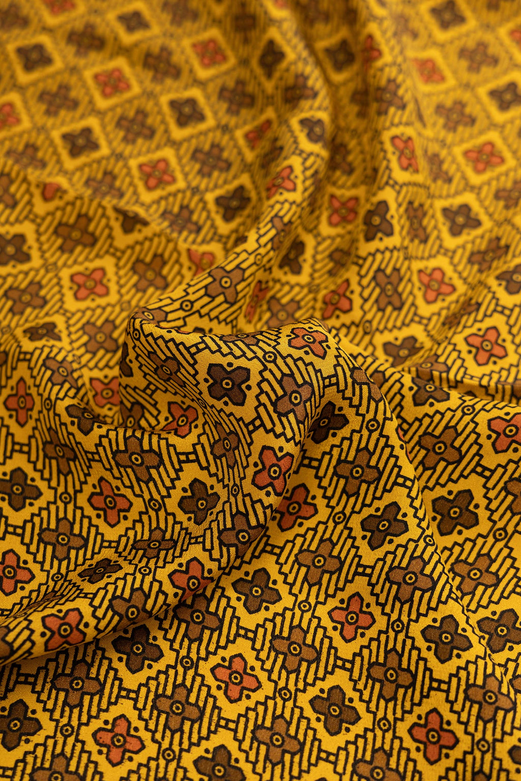 Close up of Mustard Dual Tone Printed Silk Saree with Printed design on the body and Plain Border.  displaying folds