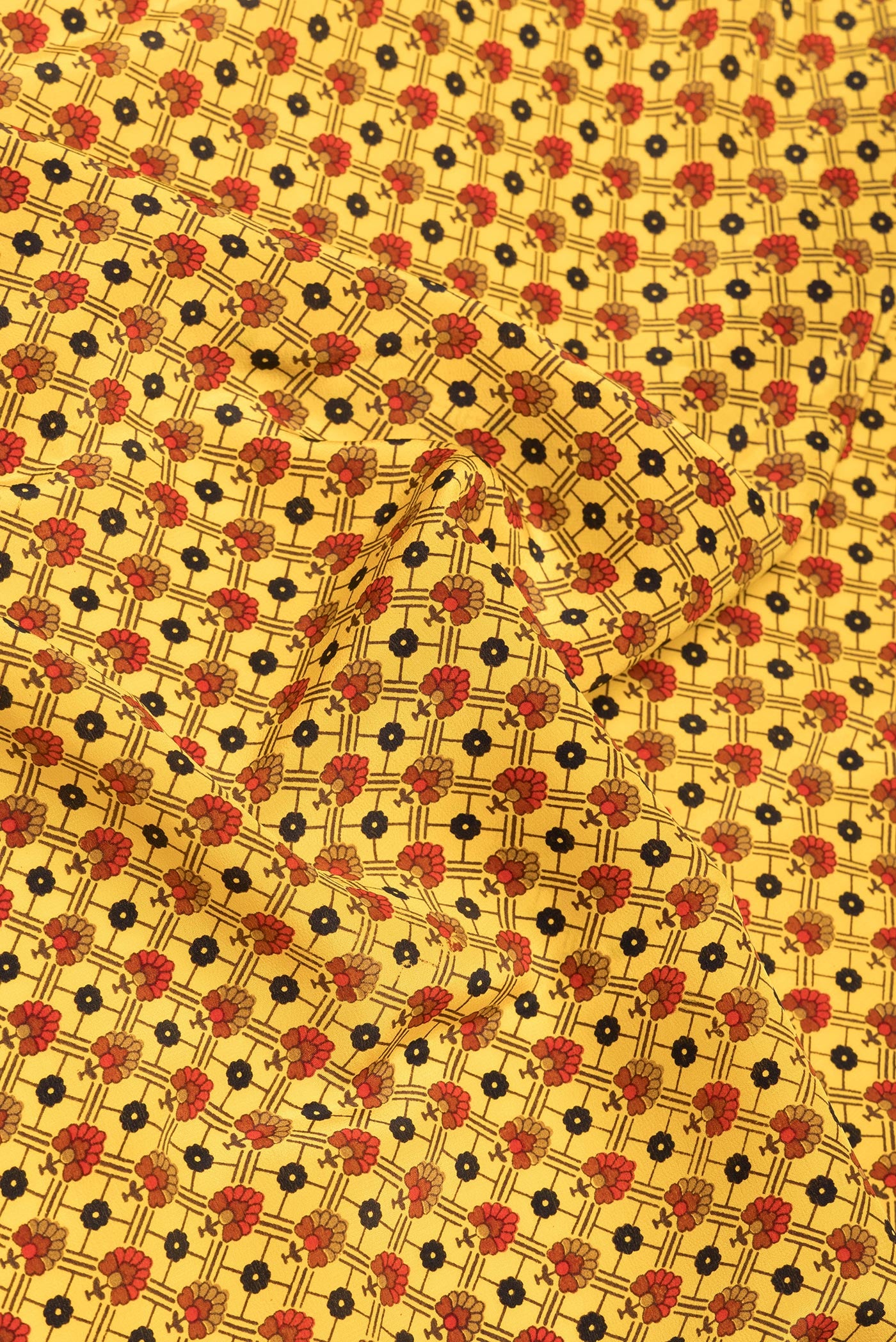 Close up of Yellow Crepe Saree with Printed design on the body and Printed Border.  displaying folds