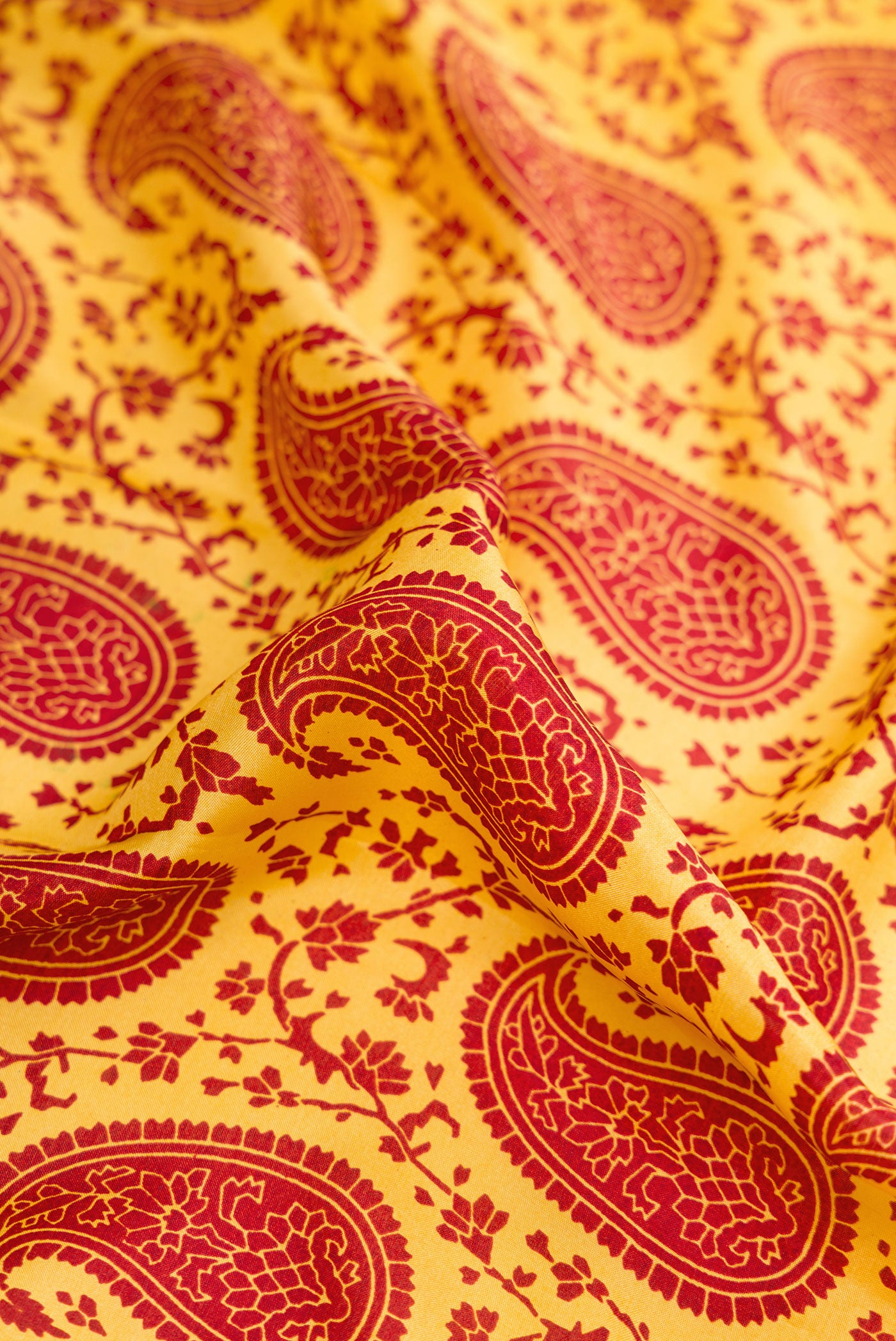 Close up of Yellow Dual Tone Printed Silk Saree with Printed design on the body and Printed Border.  displaying folds