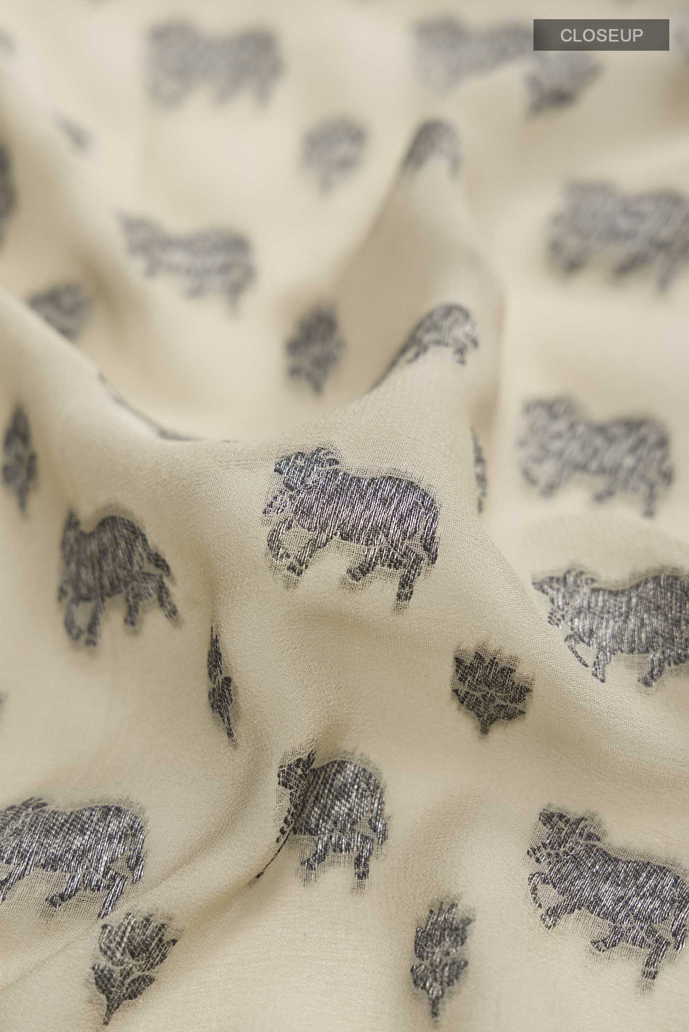 Close up of Beige Banarasi Georgette Saree with Zari Butta on the body and Zari Border displaying folds