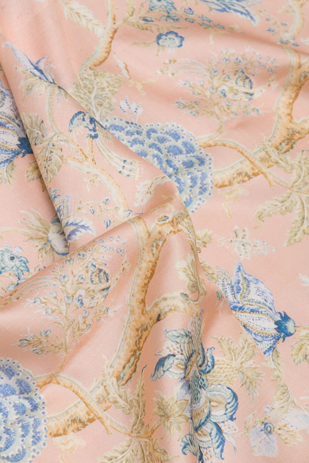 Close up of Peach Dual Tone Kanchipuram Silk Saree with Printed design on the body and Zari Border.  displaying folds