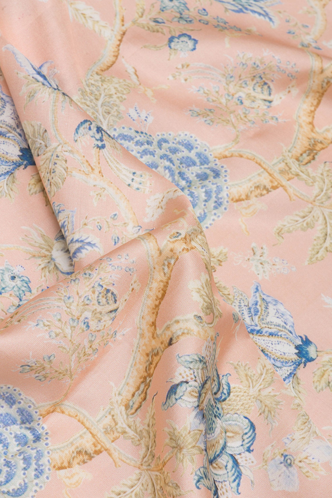 Close up of Peach Dual Tone Kanchipuram Silk Saree with Printed design on the body and Zari Border.  displaying folds