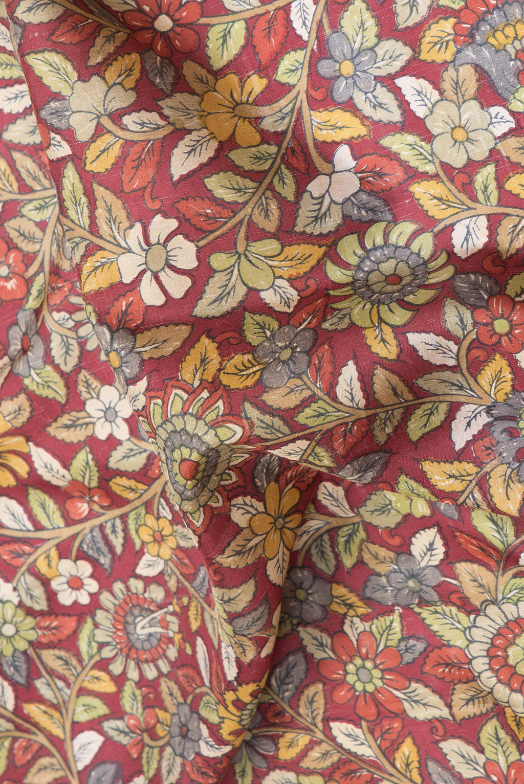 Close up of Maroon Dual Tone Kanjivaram Silk Saree with kalamkari Print on the body and Zari And Thread Border.  displaying folds