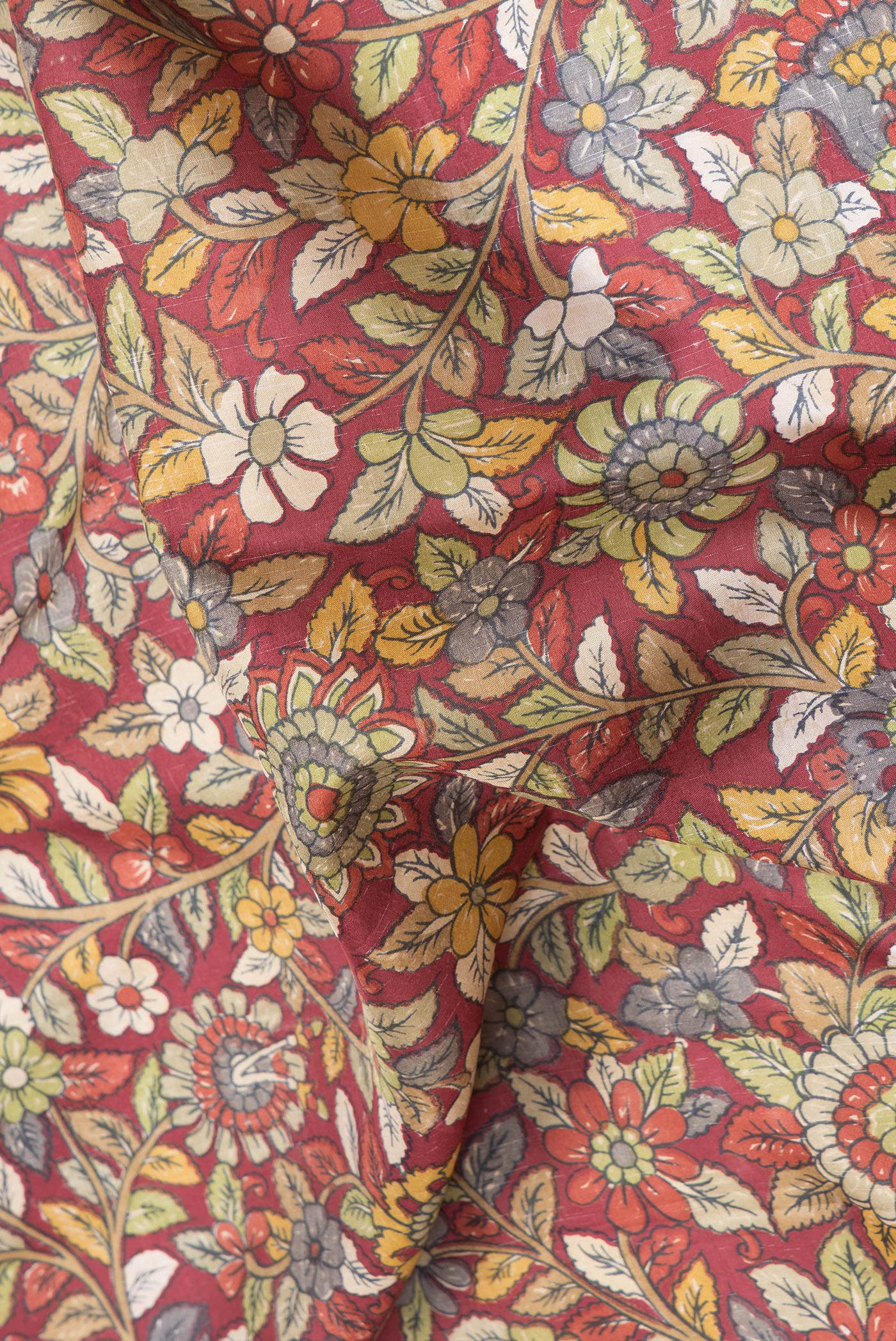 Close up of Maroon Dual Tone Kanjivaram Silk Saree with kalamkari Print on the body and Zari And Thread Border.  displaying folds