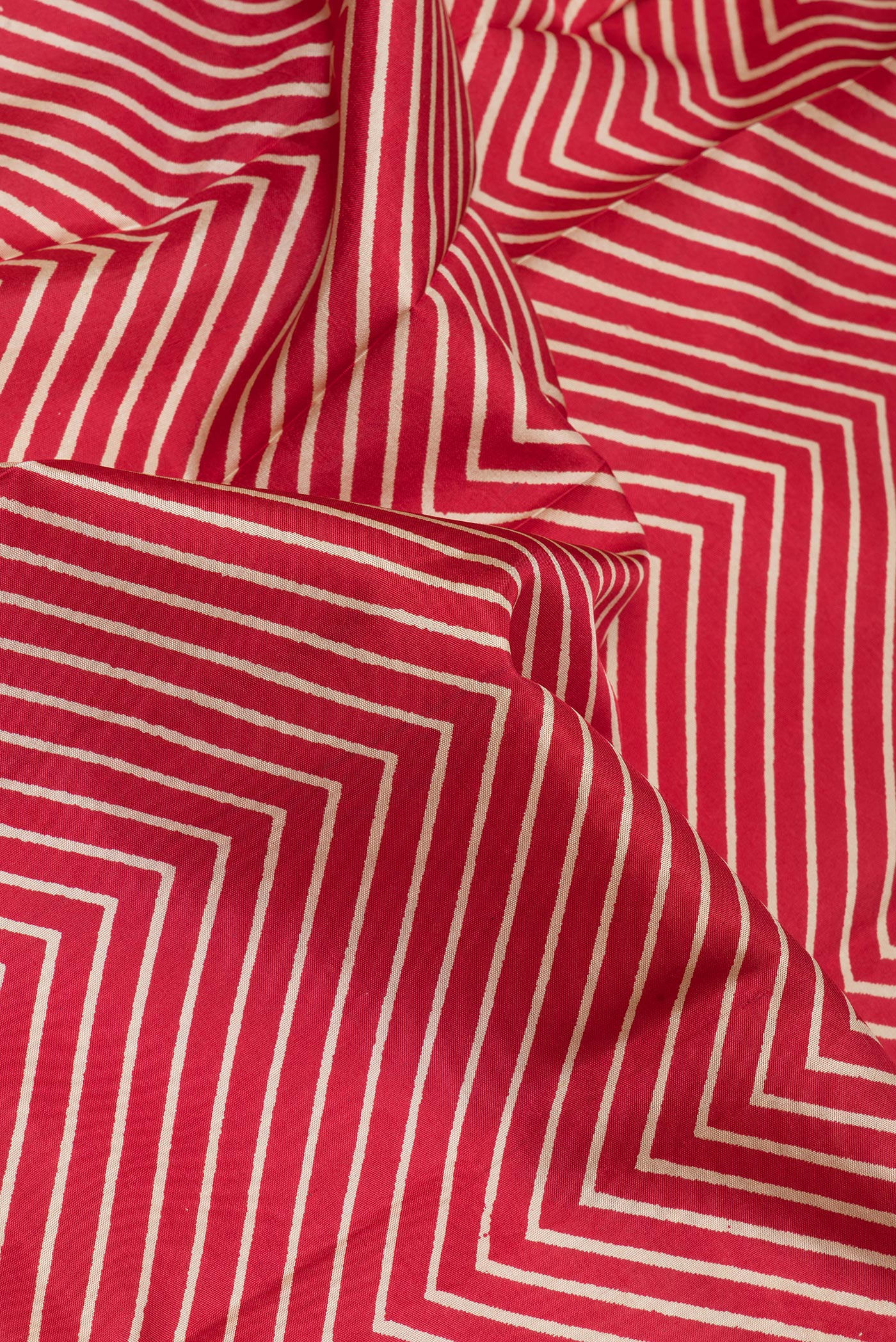 Close up of Red Dual Tone Kanchipuram Silk Saree with Printed design on the body and Printed Border.  displaying folds