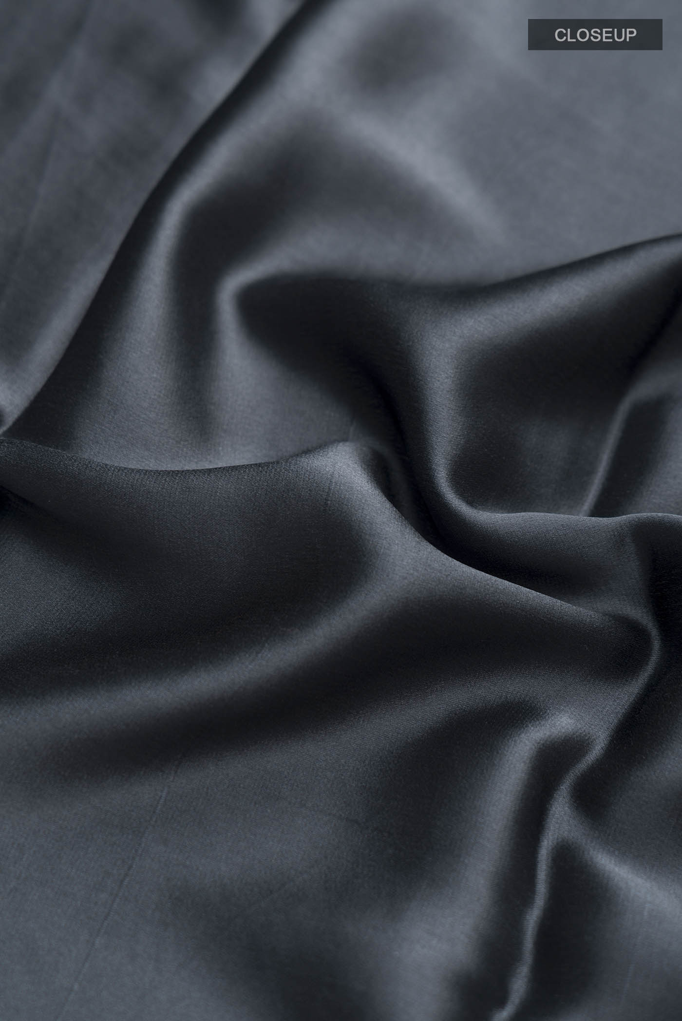 Close up of Grey Satin Silk Saree with Plain Body and Zari Border displaying folds