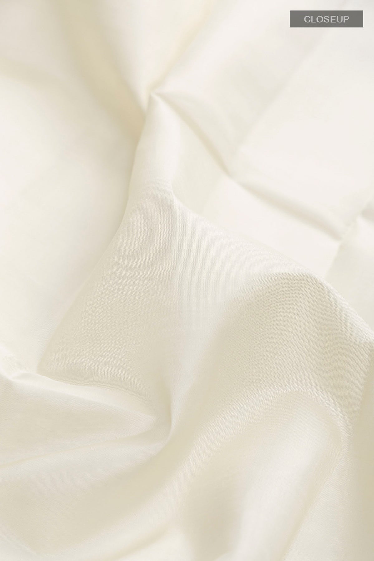 Close up of Off White Kanchipuram Silk Saree with Plain Body and Plain Border displaying folds