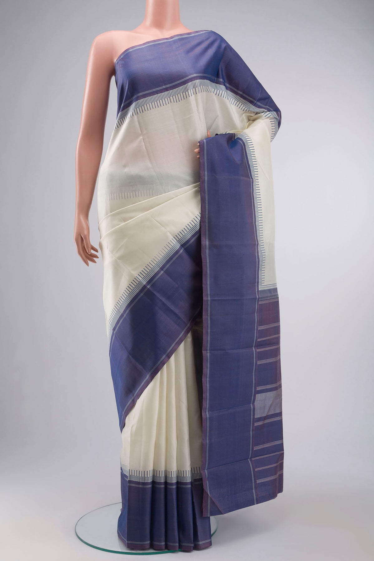 Off White Kanchipuram Silk Saree with Plain Body and Plain Border displayed on a mannequin