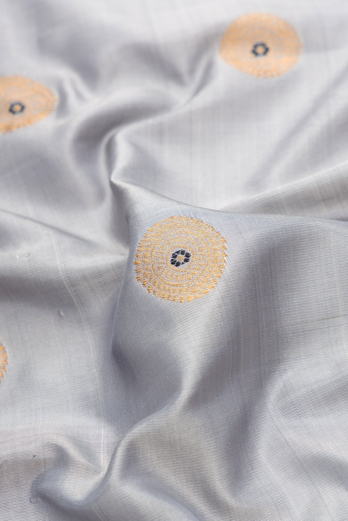 Close up of Grey Dual Tone Gadwal Silk Saree with Zari And Thread Butta on the body and Ganga Jamuna Border.  displaying folds