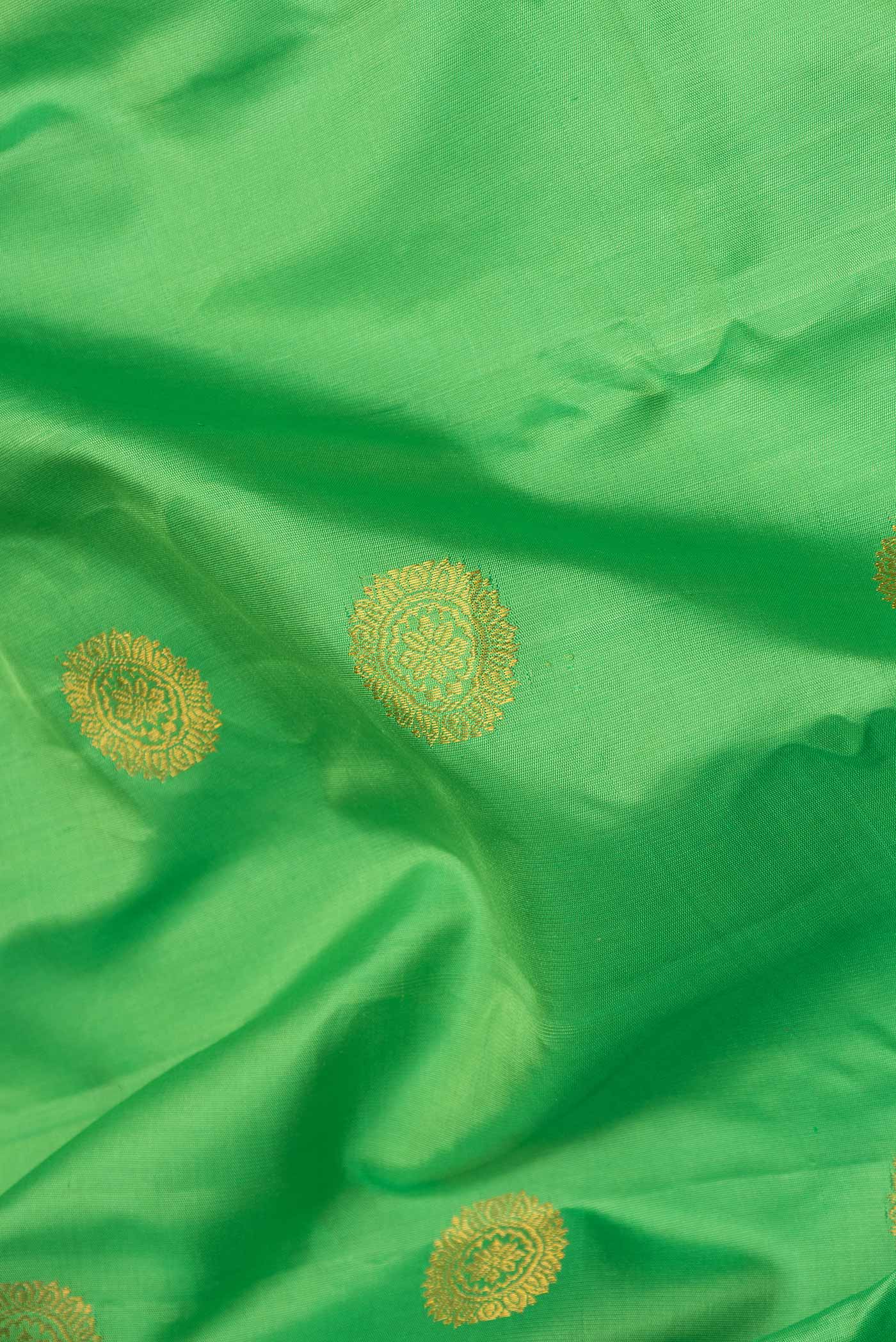 Close up of Parrot Green Dual Tone Gadwal Silk Saree with Zari Butta on the body and Ganga Jamuna Border displaying folds