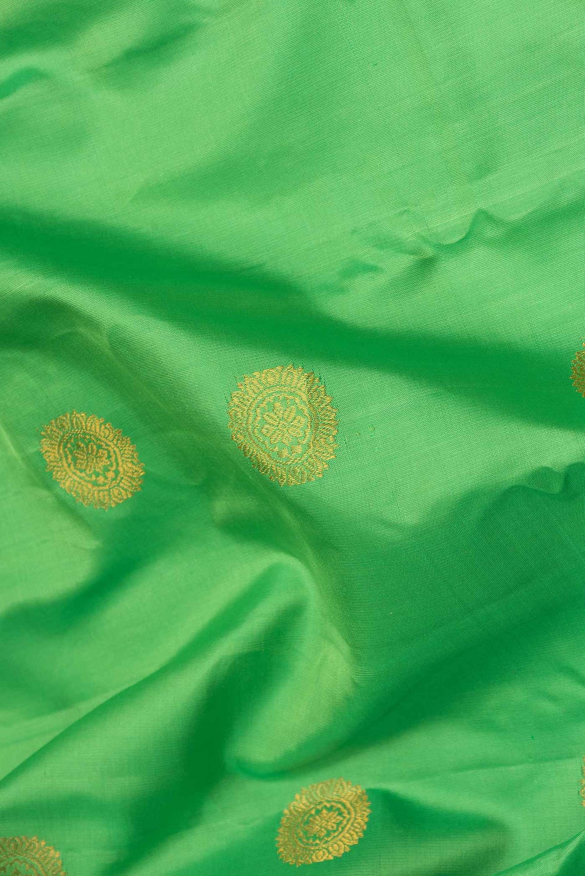 Close up of Parrot Green Dual Tone Gadwal Silk Saree with Zari Butta on the body and Ganga Jamuna Border displaying folds