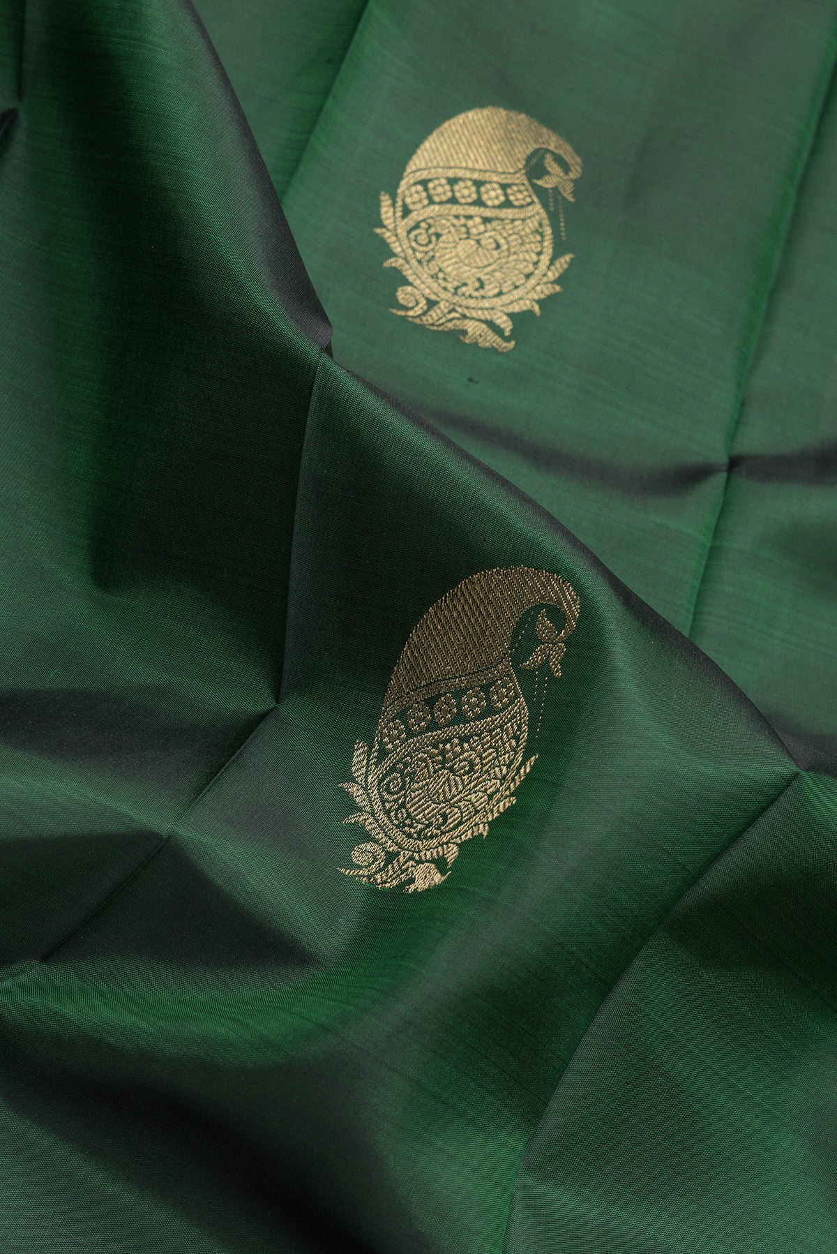 Close up of Bottle Green Dual Tone Kanchipuram Silk Saree with Zari Butta on the body and Zari Border.  displaying folds