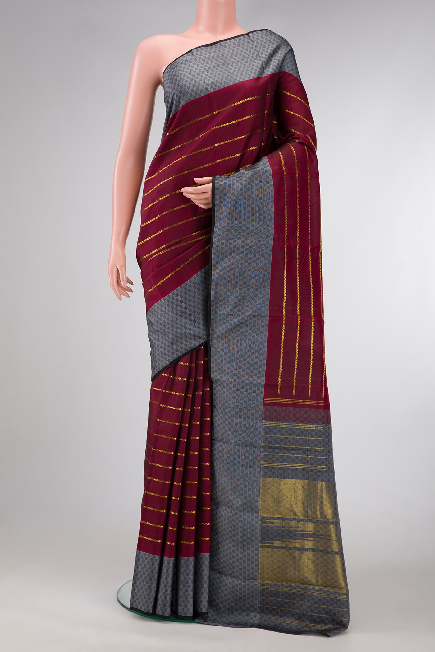 Maroon Dual Tone Kanchipuram Silk Saree with Stripes on the body and Checks Border.  displayed on a mannequin