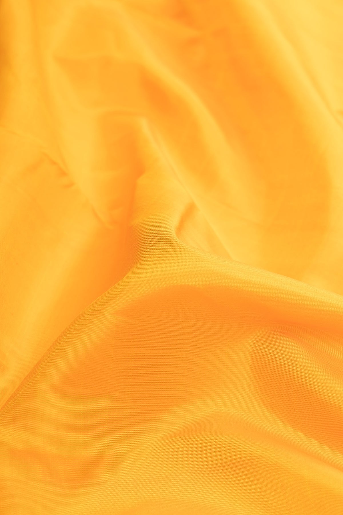 Close up of Pure Silk Pure Zari Mustard Dual Tone Kanjivaram Saree with Plain Body and Zari Border.  displaying folds