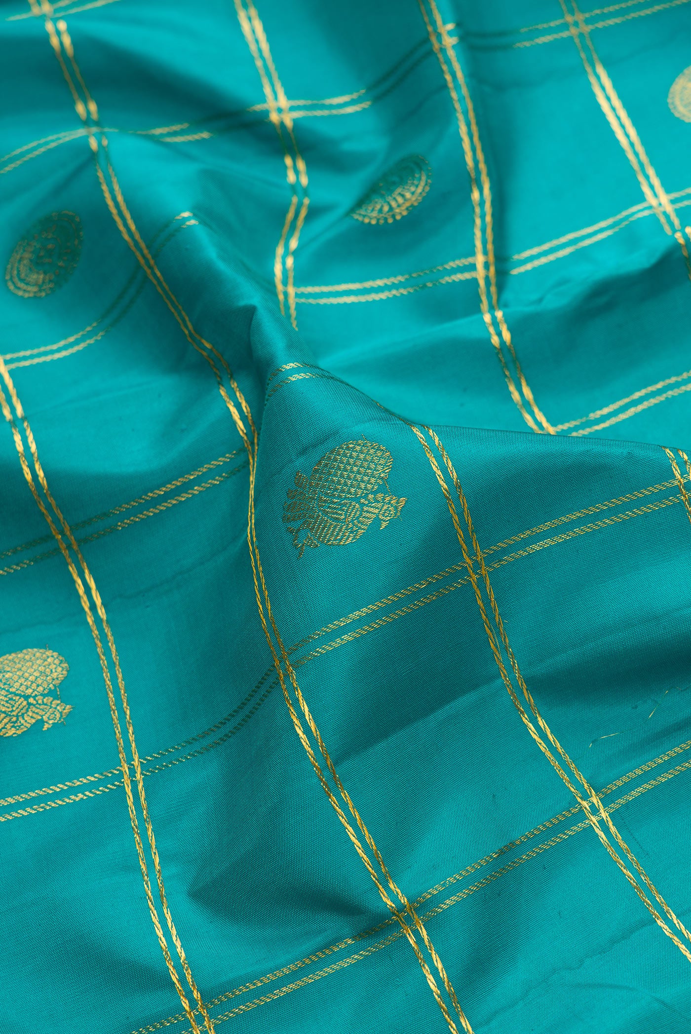 Close up of Green Dual Tone Kanjivaram Silk Saree with Checked design on the body and Zari Border.  displaying folds