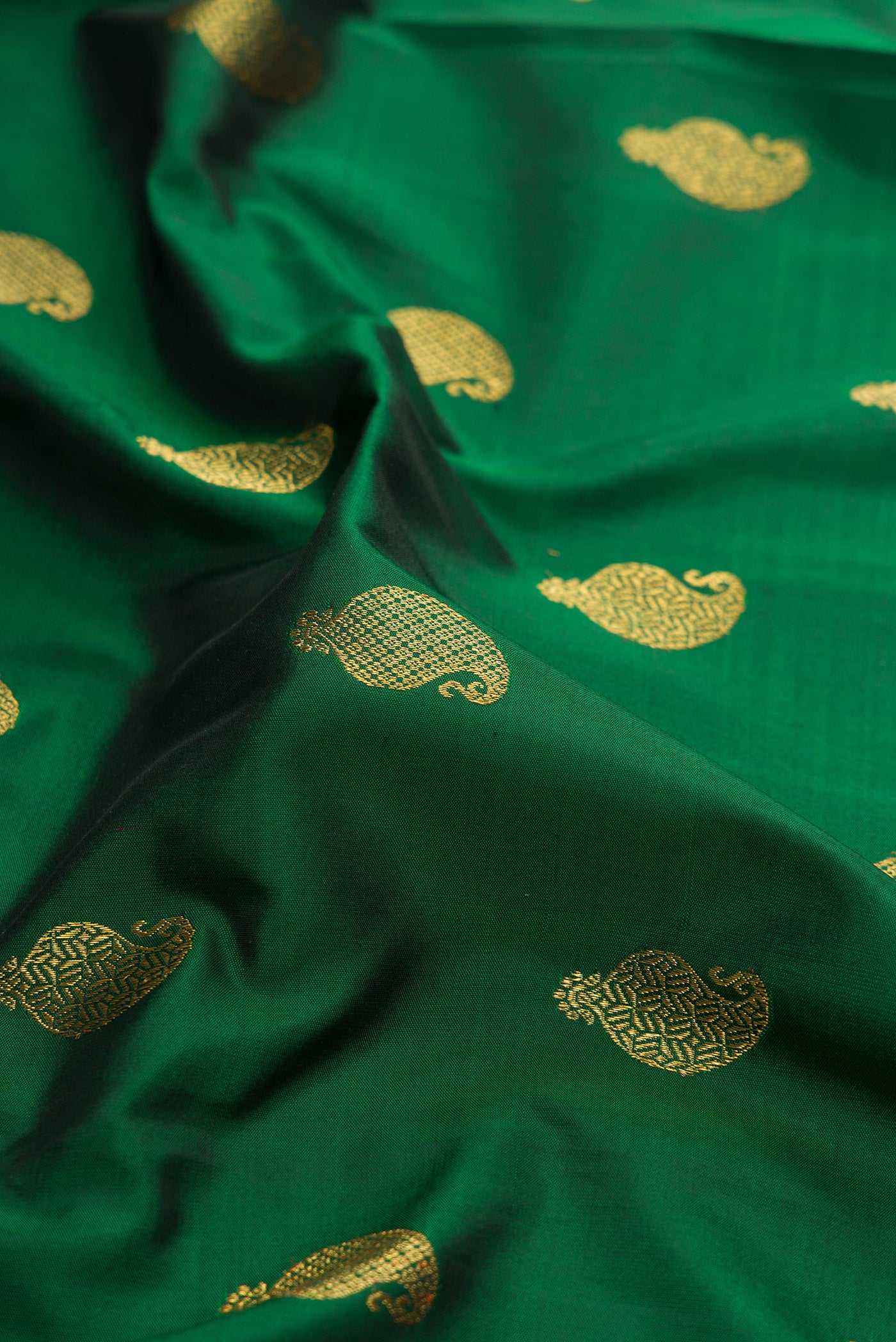 Close up of Pure Silk Pure Zari Green Kanjivaram Saree with Zari Butta on the body and Zari Border.  displaying folds