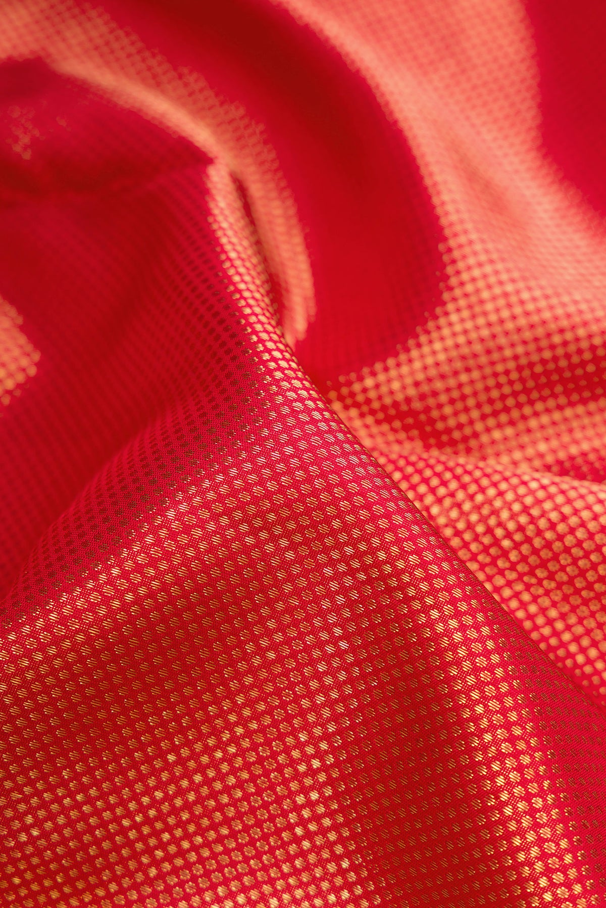 Close up of Pure Silk Pure Zari Red Dual Tone Kanjivaram Saree with Zari Brocade on the body and Zari Border.  displaying folds