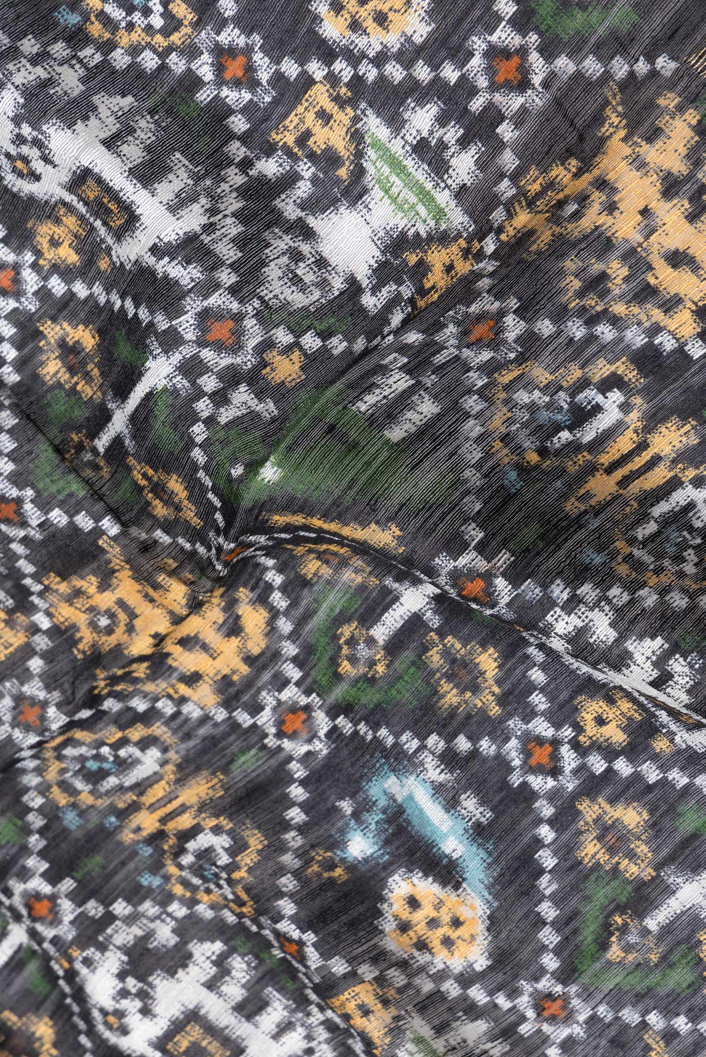 Close up of Black Dual Tone Tussar Silk Saree with Printed design on the body and Zari Border.  displaying folds
