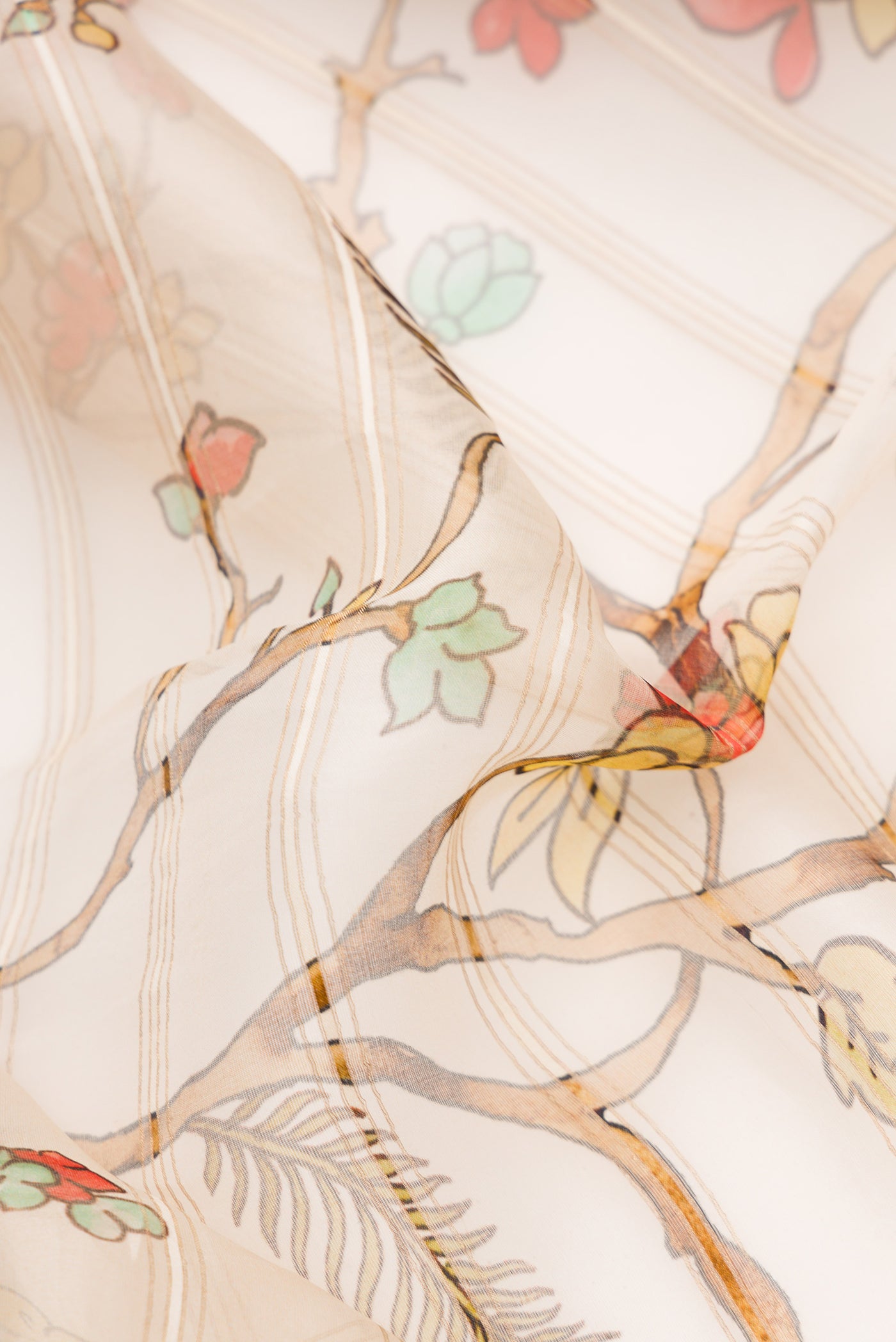 Close up of Beige Dual Tone Organza Silk Saree with Printed design on the body and Embroidery Border.  displaying folds