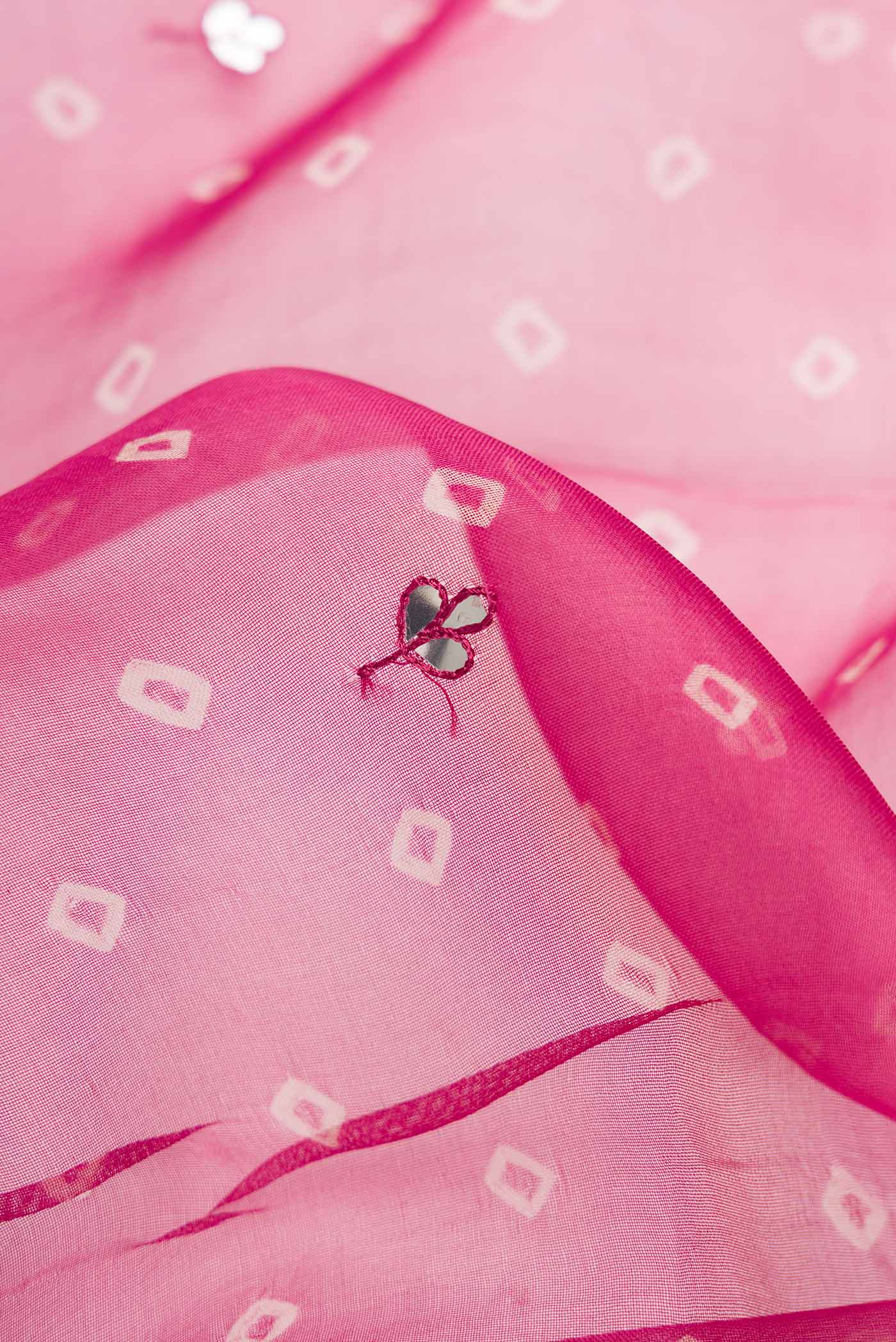 Close up of Maroon Dual Tone Organza Silk Saree with Embroidery on the body and Embroidery Border.  displaying folds