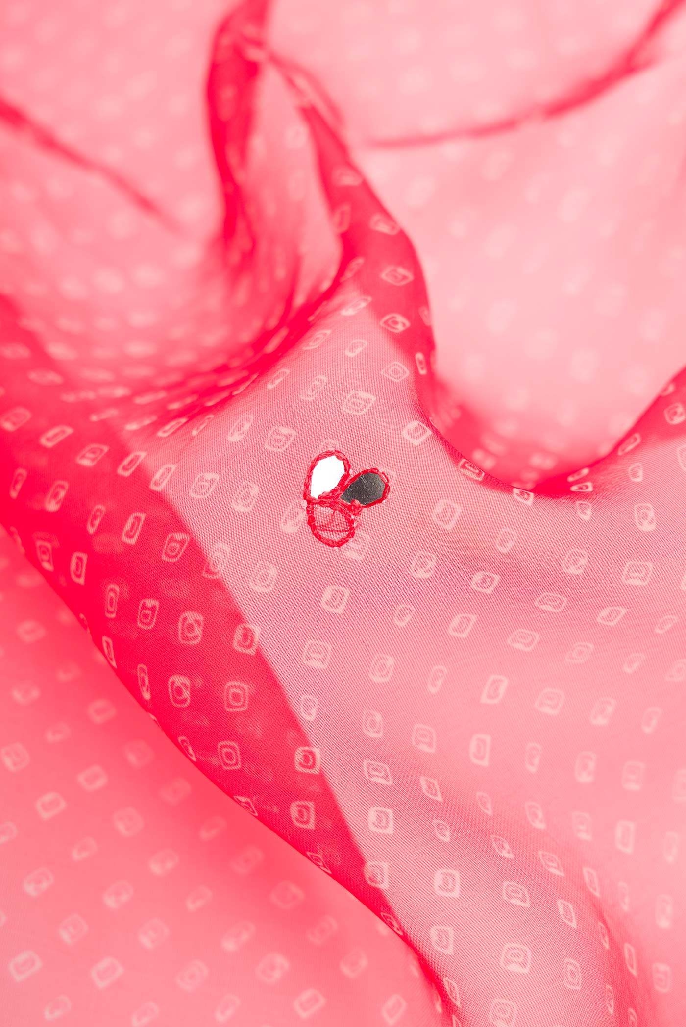 Close up of Red Dual Tone Organza Silk Saree with Embroidery on the body and Embroidery Border.  displaying folds