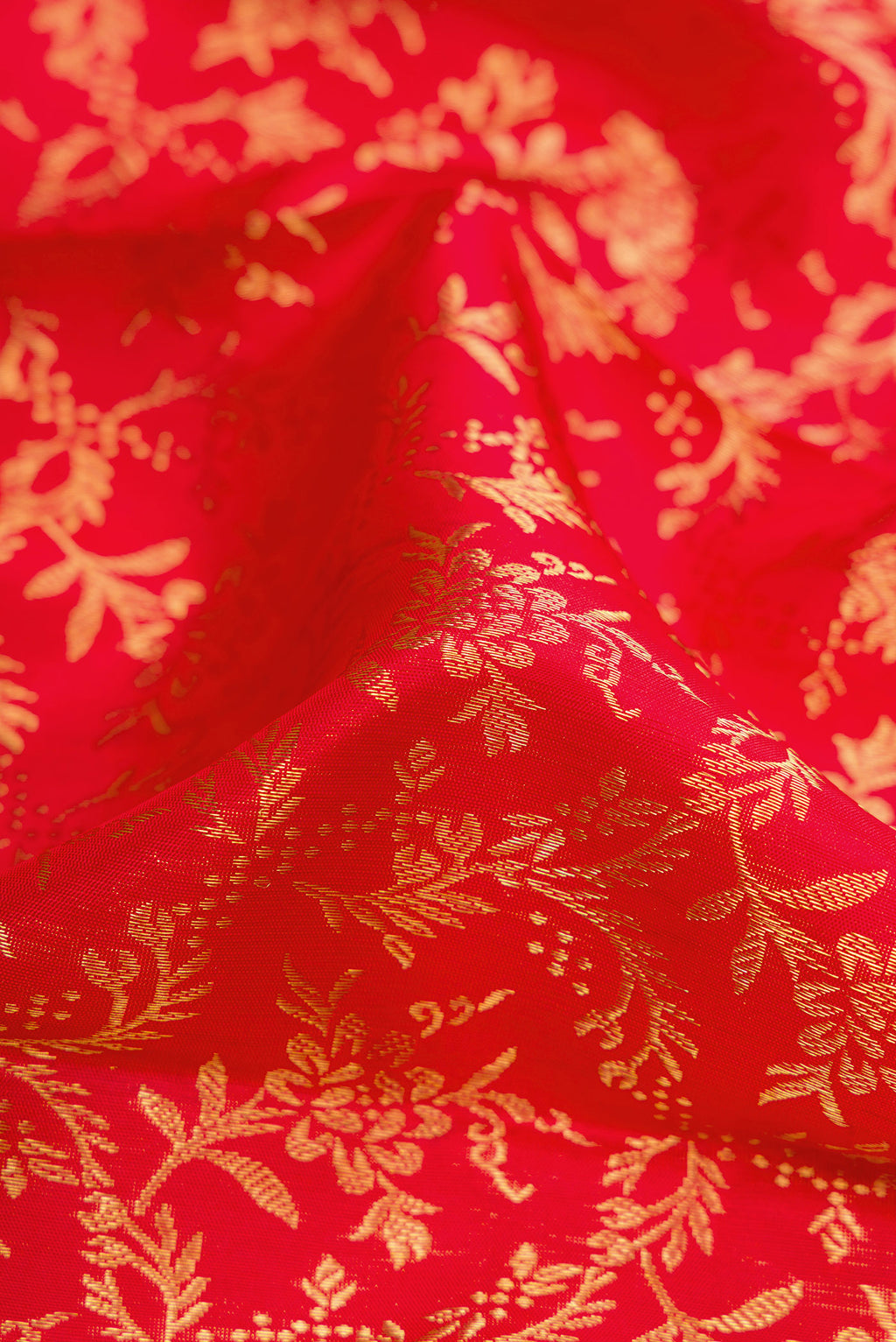Close up of Red Dual Tone Kanjivaram Silk Saree with Zari Brocade on the body and Zari Border.  displaying folds