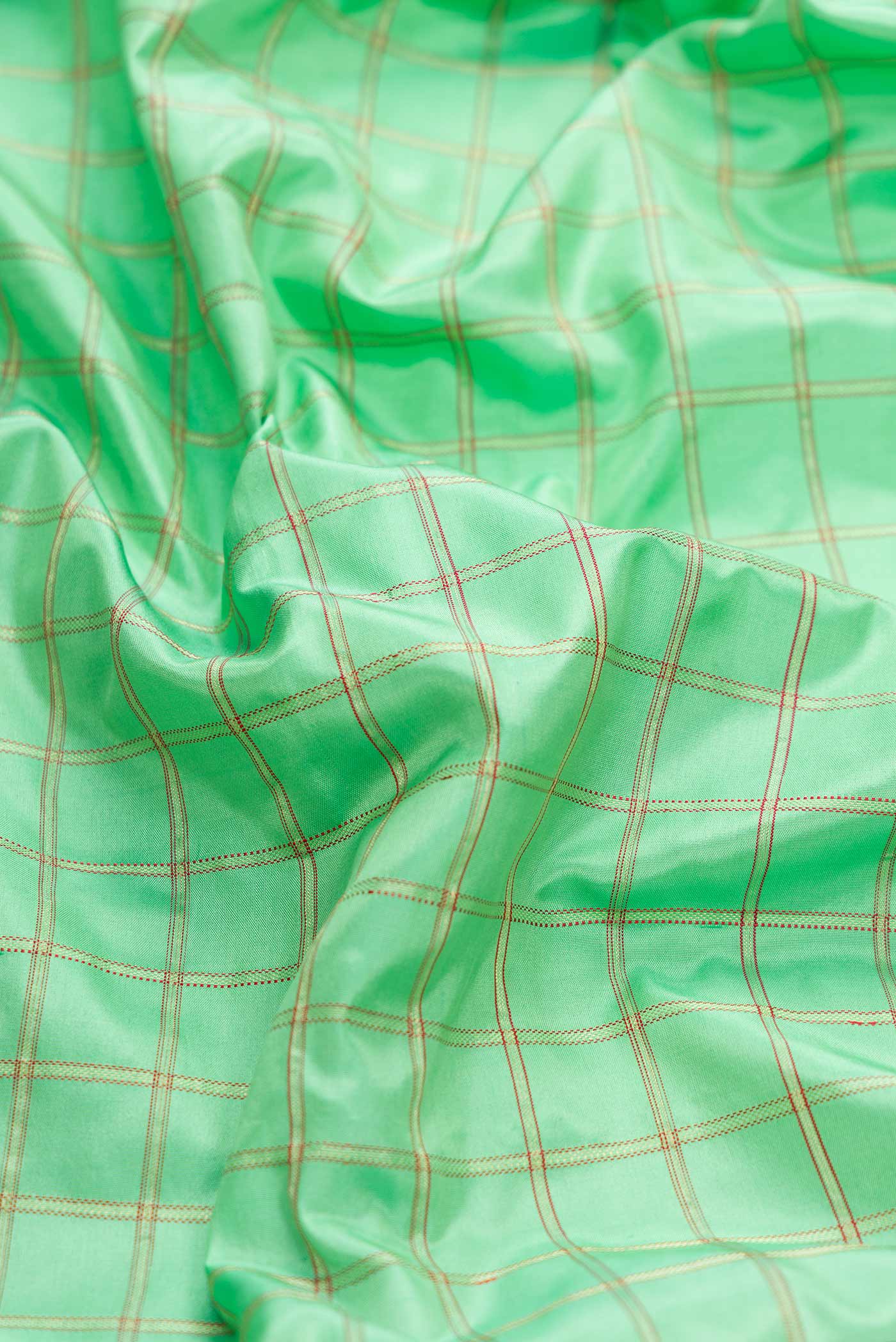 Close up of Pure Silk Pure Zari Parrot Green Dual Tone Banarasi Saree with Checked design on the body and Zari Border displaying folds
