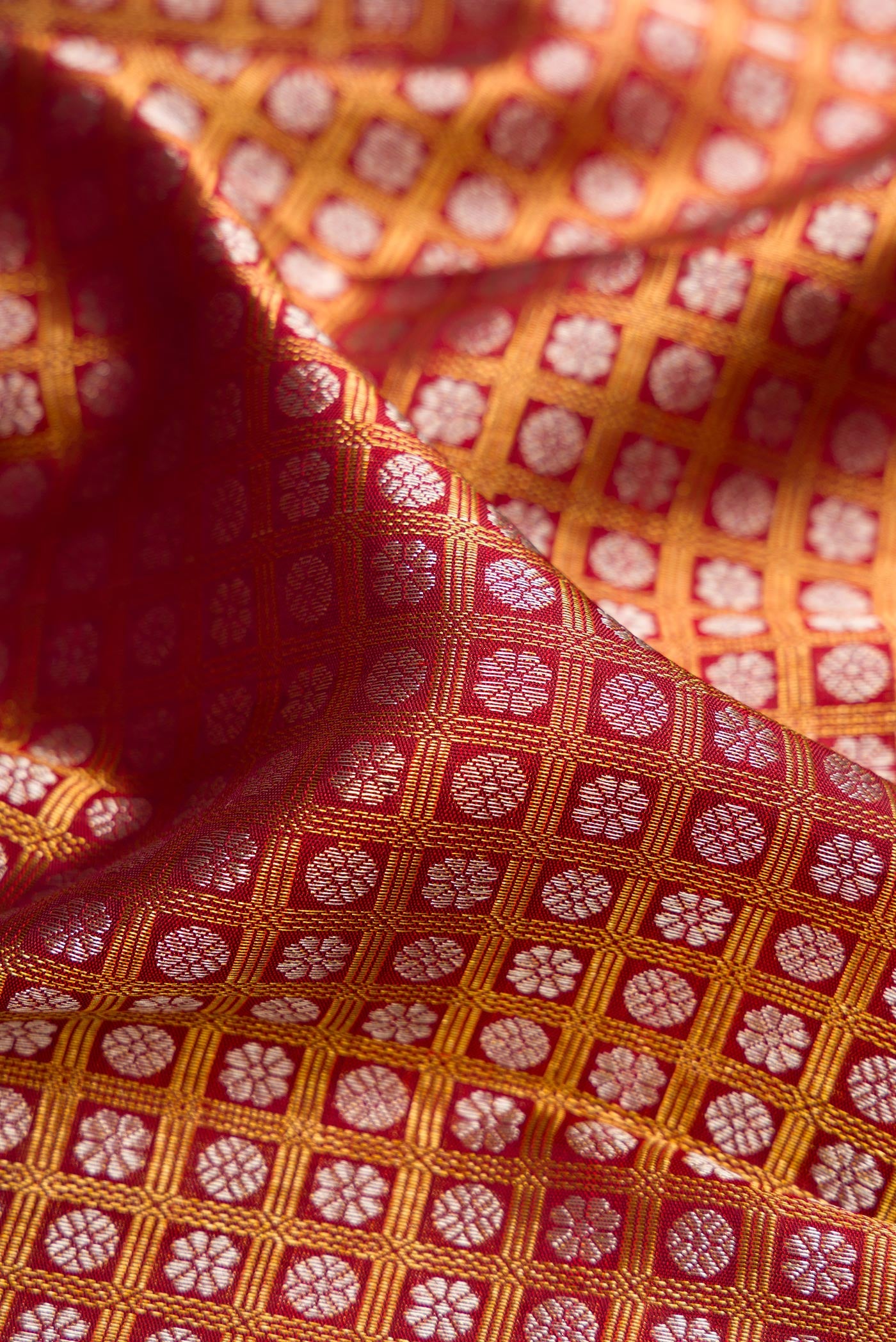 Close up of Maroon Kanchipuram Silk Saree with Zari Brocade on the body and Zari Border.  displaying folds