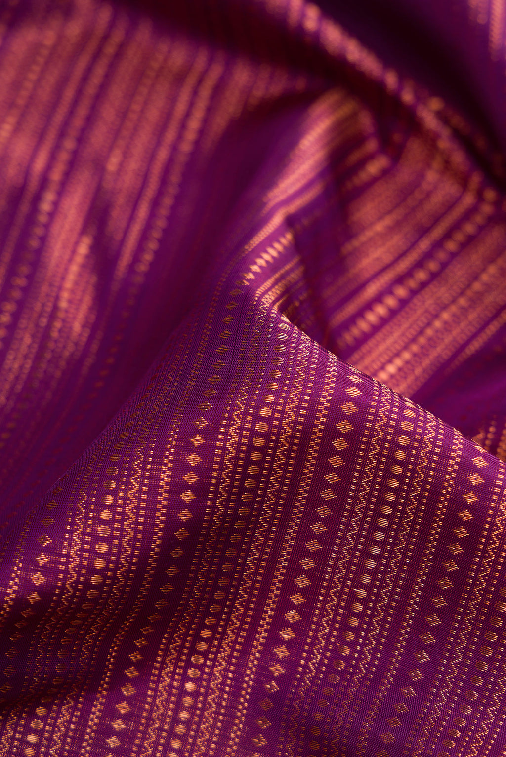 Close up of Purple Dual Tone Kanjivaram Silk Saree with Zari Brocade on the body and Fancy Border.  displaying folds