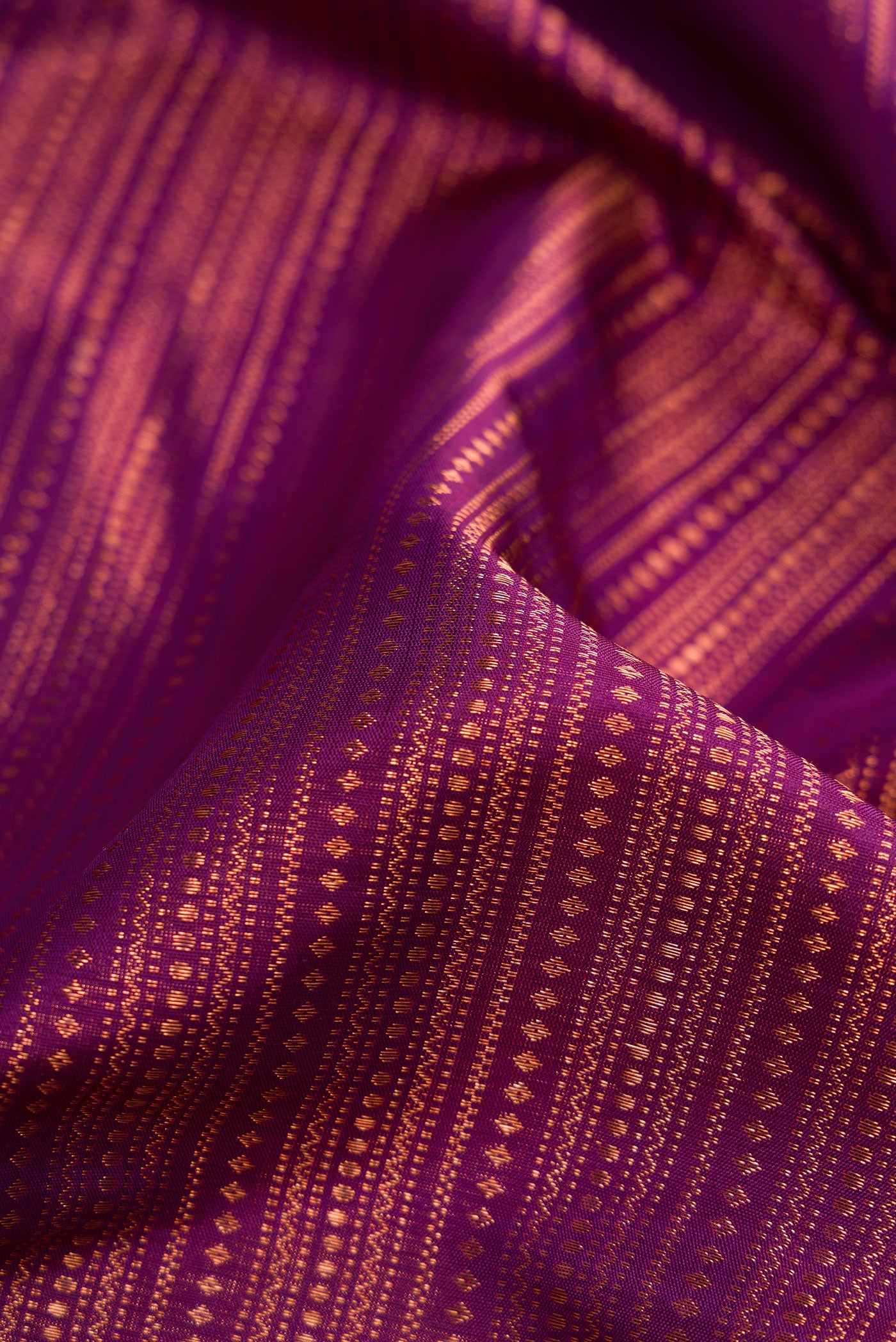 Close up of Purple Dual Tone Kanjivaram Silk Saree with Zari Brocade on the body and Fancy Border.  displaying folds