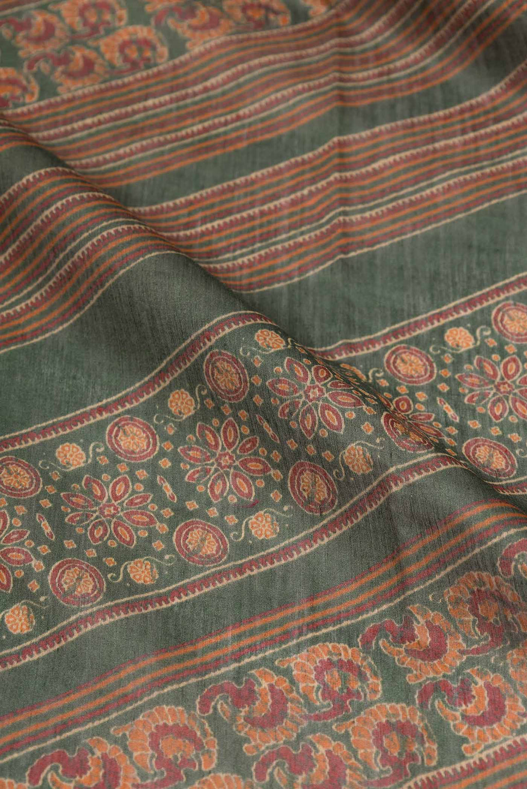 Close up of Green Dual Tone Tussar Silk Saree with Printed design on the body and Zari Border displaying folds