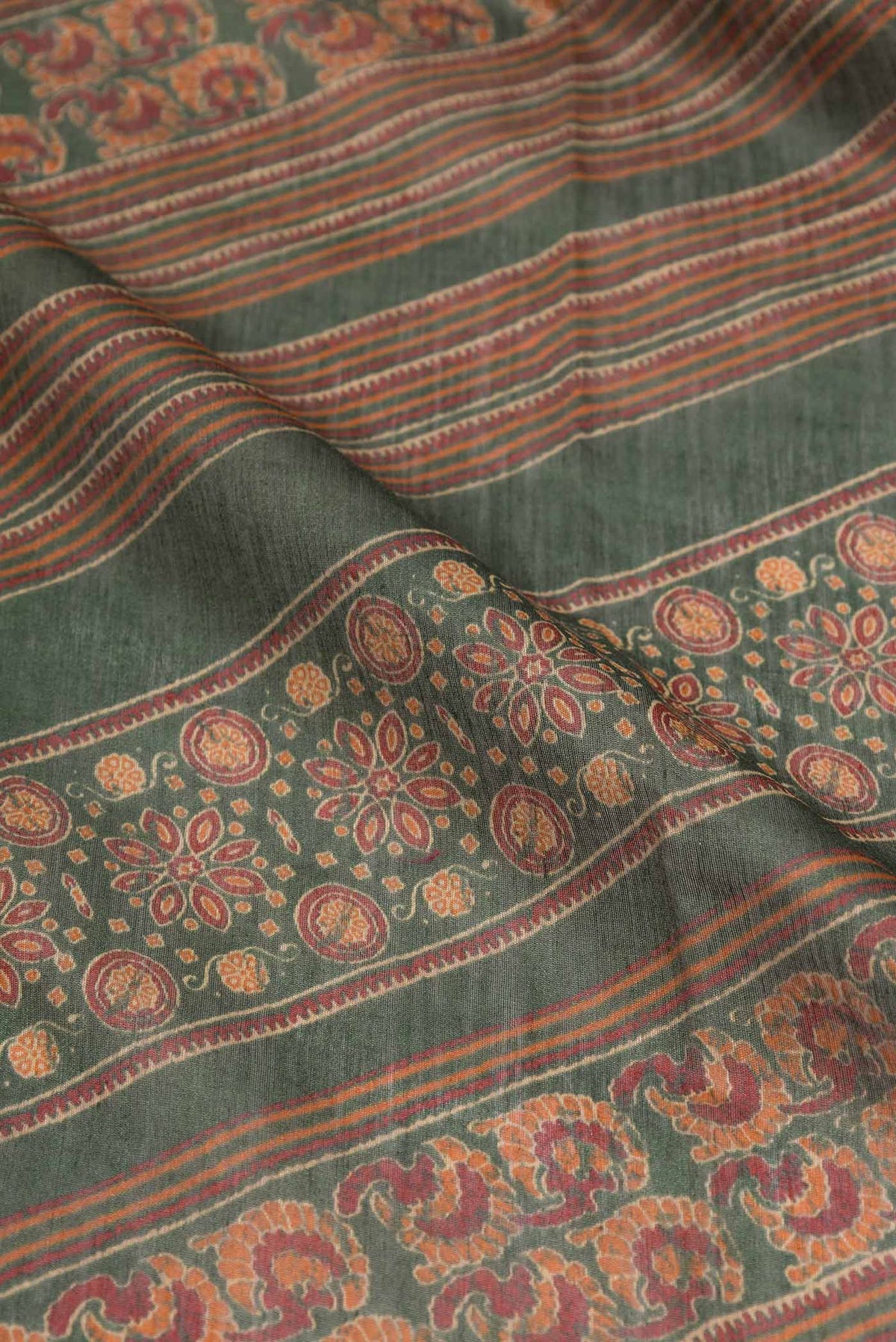 Close up of Green Dual Tone Tussar Silk Saree with Printed design on the body and Zari Border displaying folds