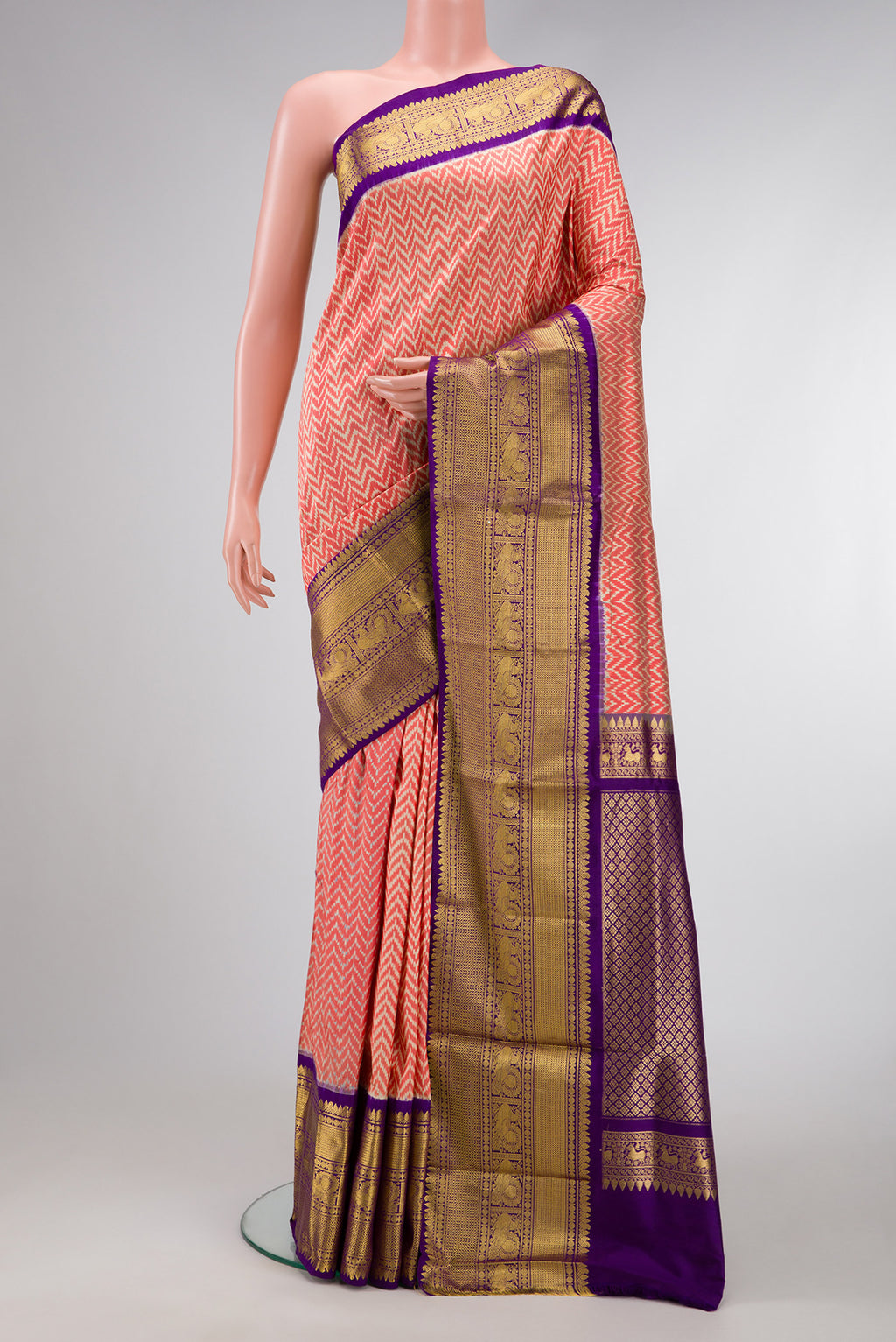 Off White and Orange Color Double Ikat Saree with Ikat Print on the body and Zari Border.  displayed on a mannequin
