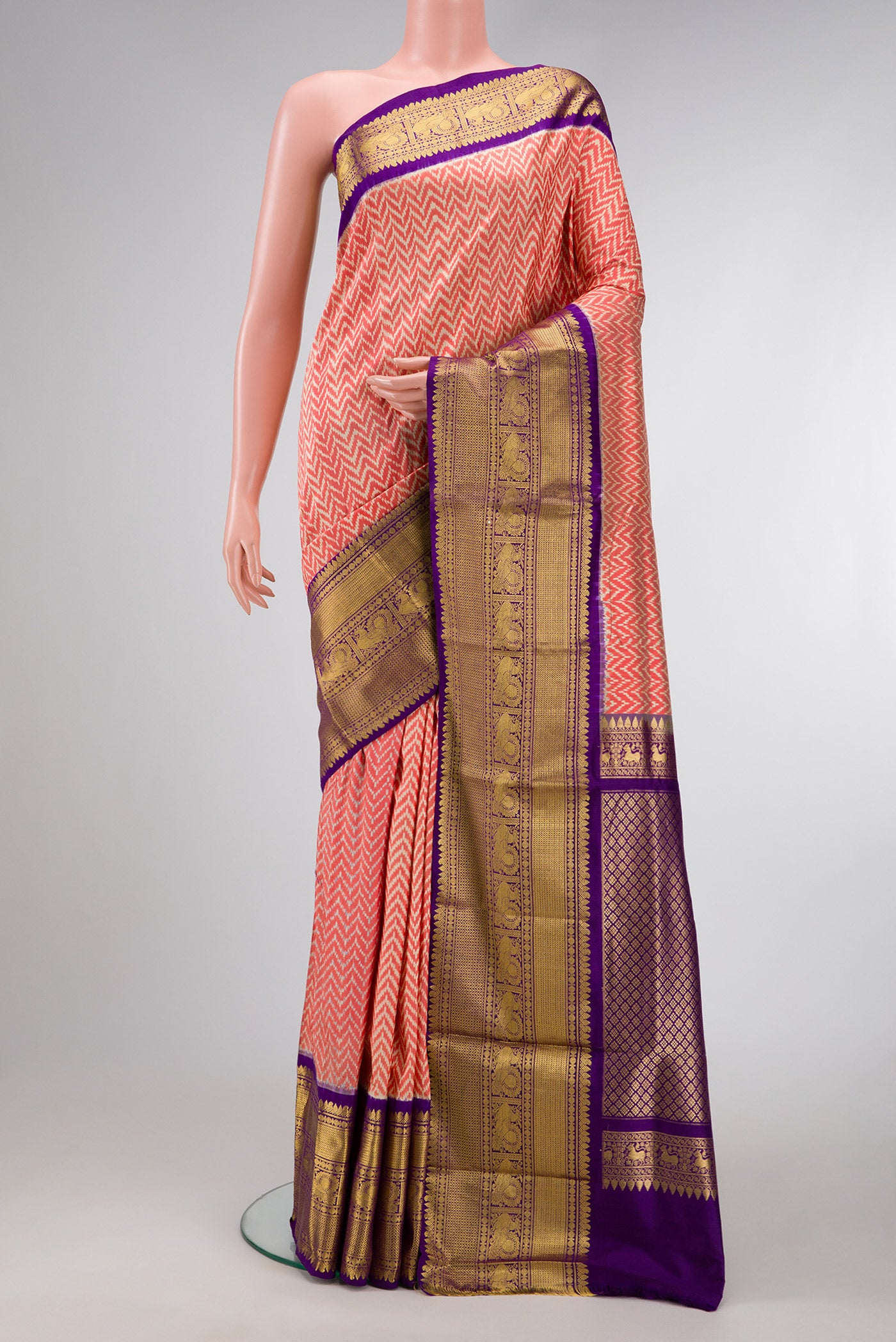 Off White and Orange Color Double Ikat Saree with Ikat Print on the body and Zari Border.  displayed on a mannequin
