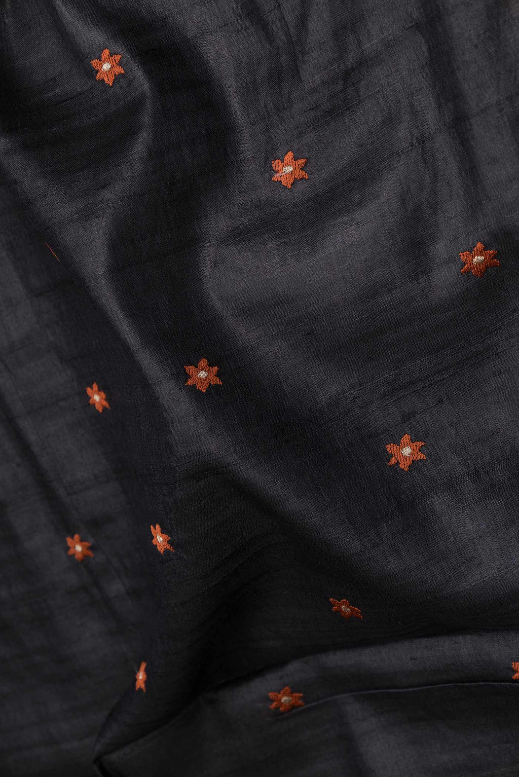 Close up of Black Tussar Silk Saree with Embroidery on the body and Embroidery Border displaying folds
