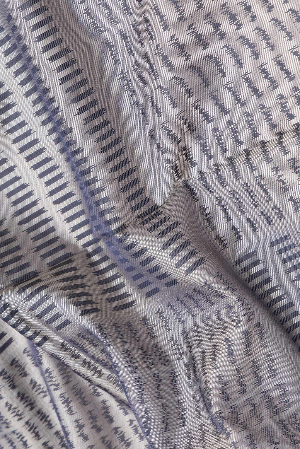 Close up of Grey Dual Tone Rajkot Patola Silk Saree with Ikat Print on the body and Zari Border.  displaying folds