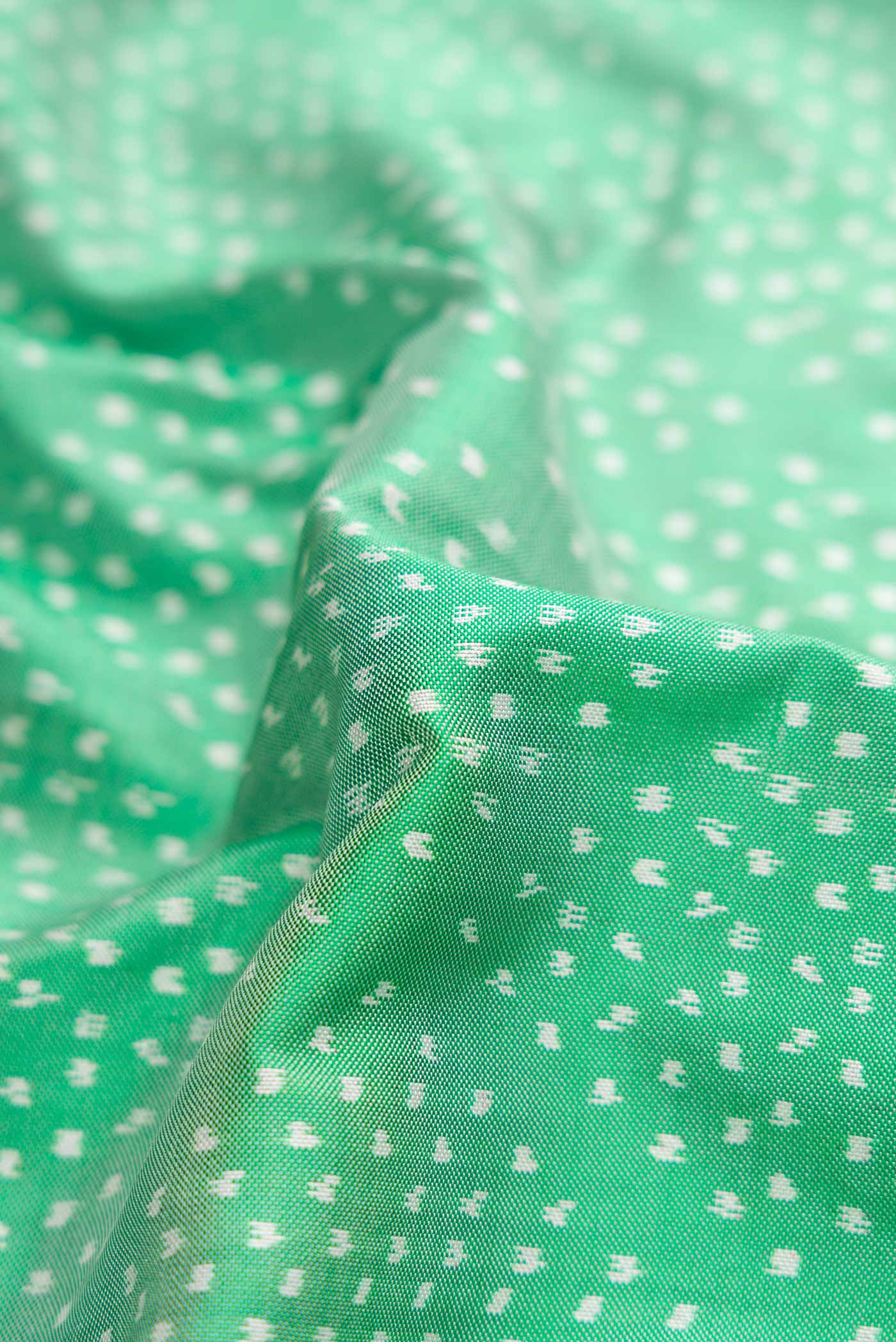 Close up of Sea Green Pochampally Silk Saree with Pure Ikat on the body and Zari Border displaying folds