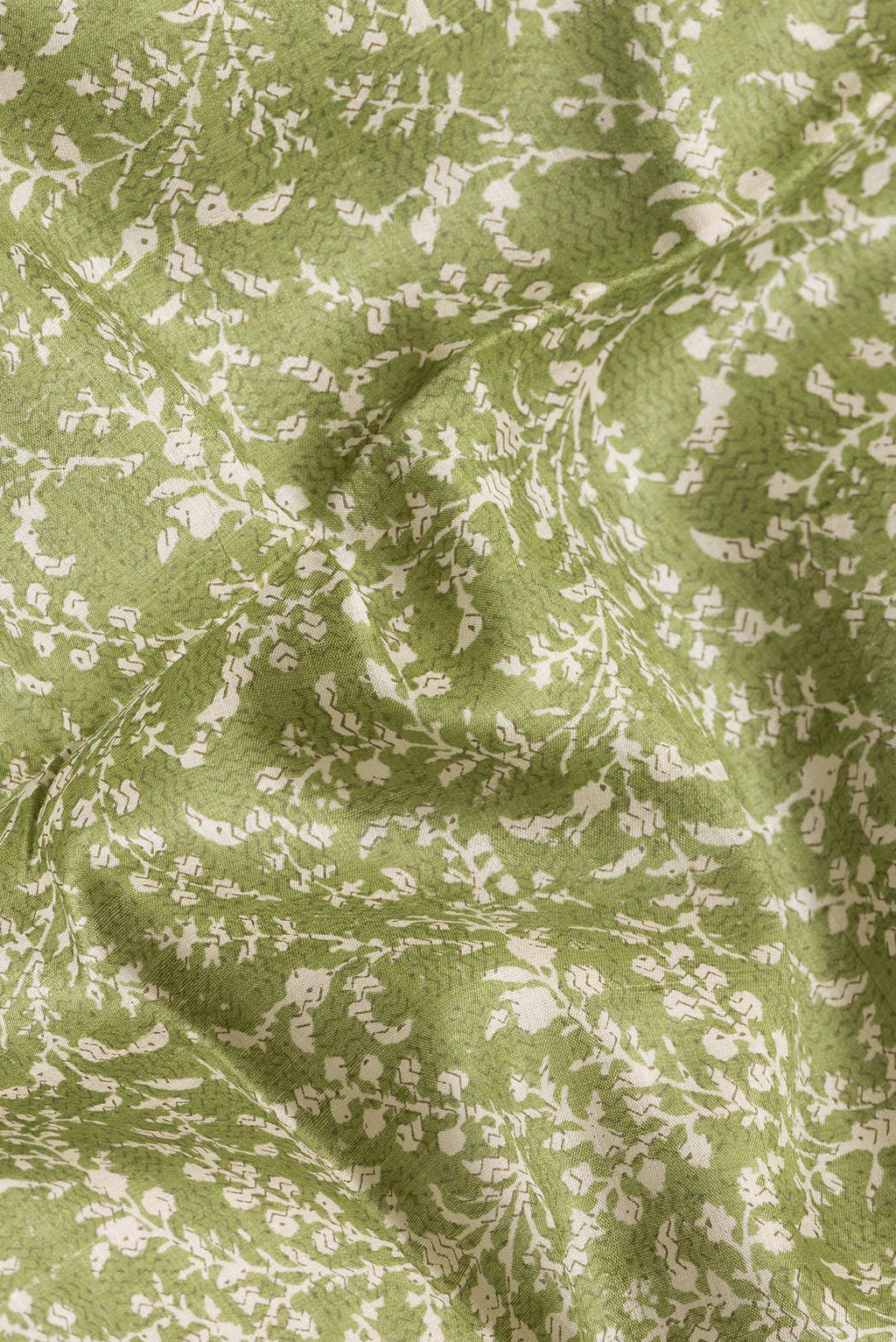 Close up of Green Dual Tone Tussar Silk Saree with Printed design on the body and Zari Border.  displaying folds
