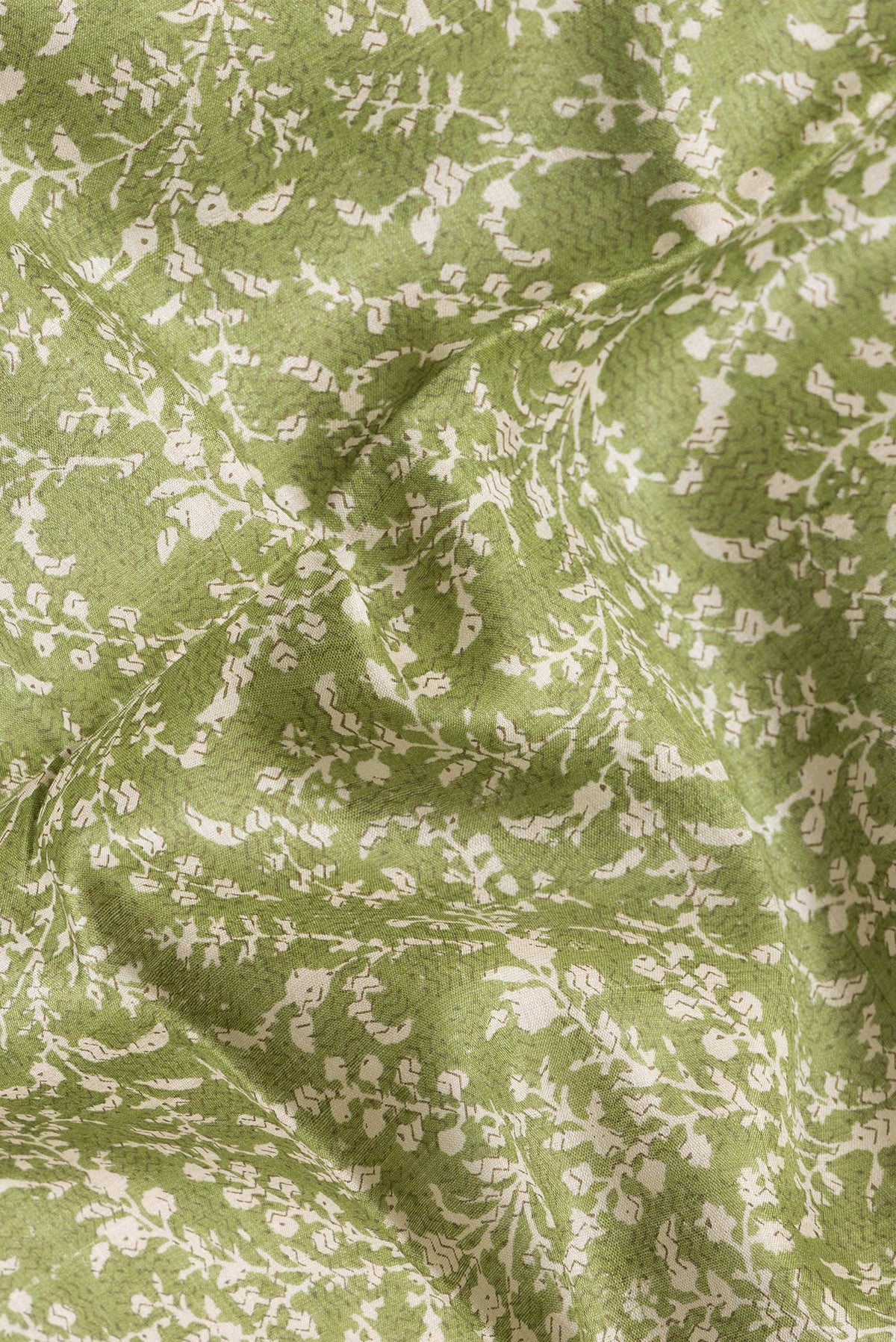 Close up of Green Dual Tone Tussar Silk Saree with Printed design on the body and Zari Border.  displaying folds