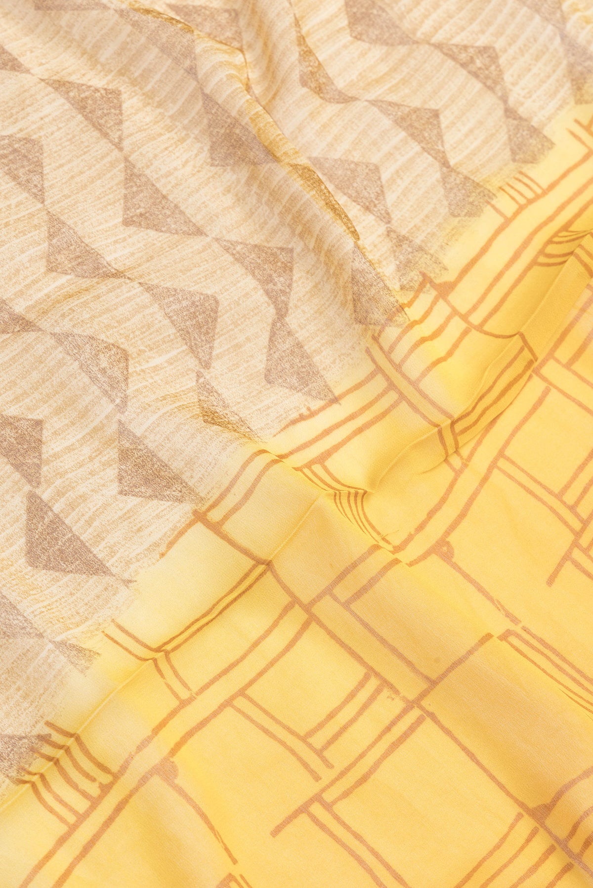 Close up of Yellow Dual Tone Mysore Georgette Saree with Printed design on the body and Zari And Thread Border.  displaying folds