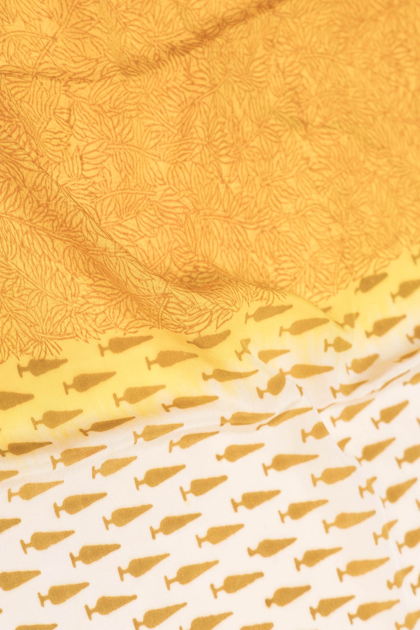Close up of Beige Dual Tone Mysore Crepe Saree with Printed design on the body and Plain Border displaying folds